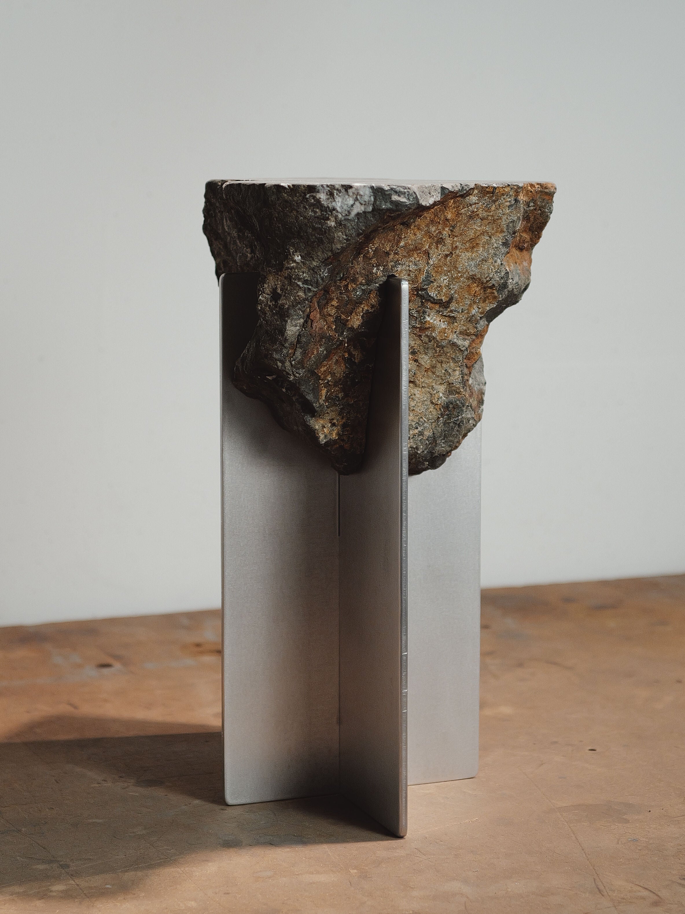 Hybrid Objects side table detail showing raw stone balanced on metal base by Estudio Material