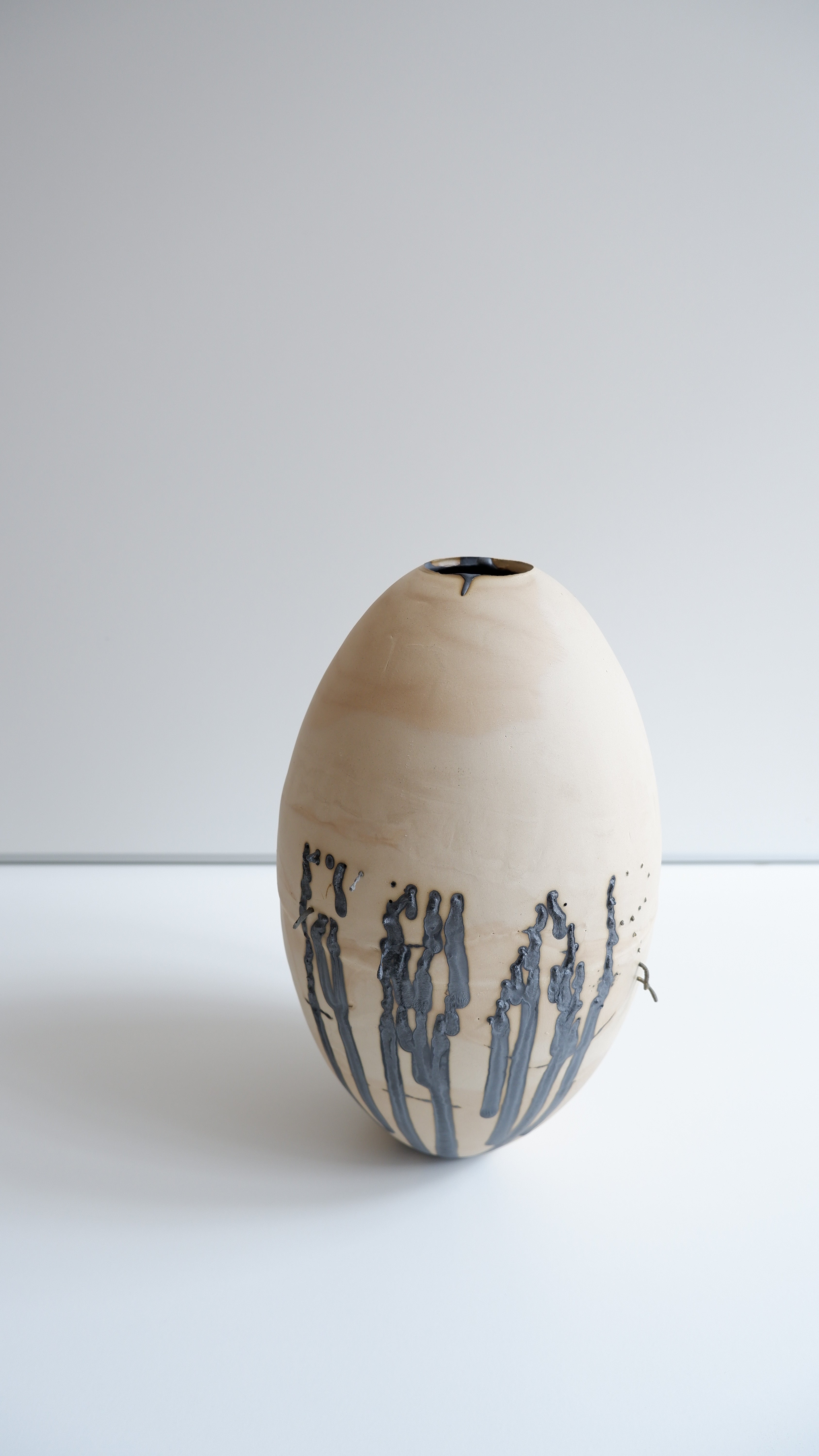 FEAR Vessel — side angle showing natural clay with black detailing