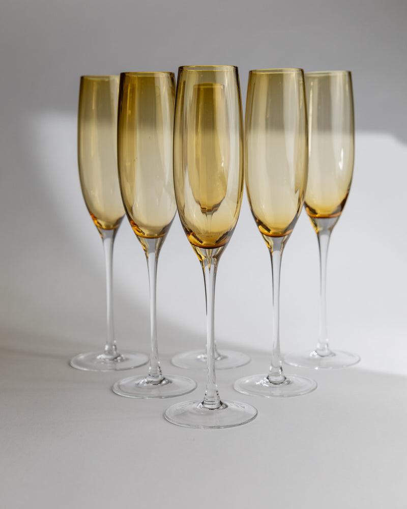 Set of five amber Murano glass champagne flutes with clear stems