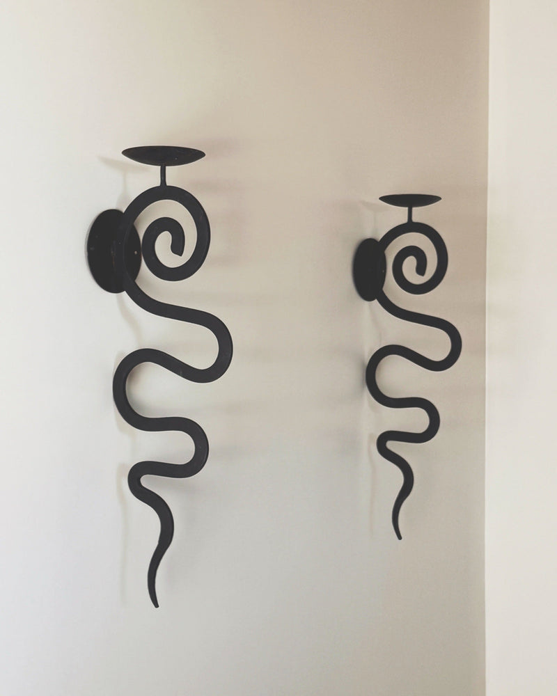 Pair of black wrought iron spiral wall sconces with candle holders
