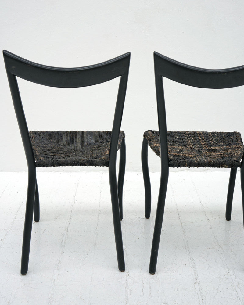 Black Manila dining chairs rear view showing woven rush seats