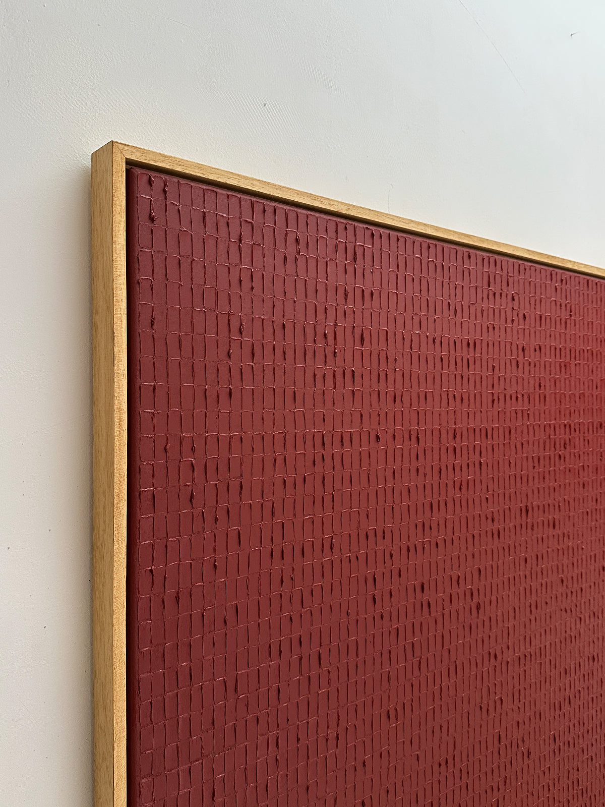Textured Indian red painting detail with geometric brick pattern by Roi Elmaliah