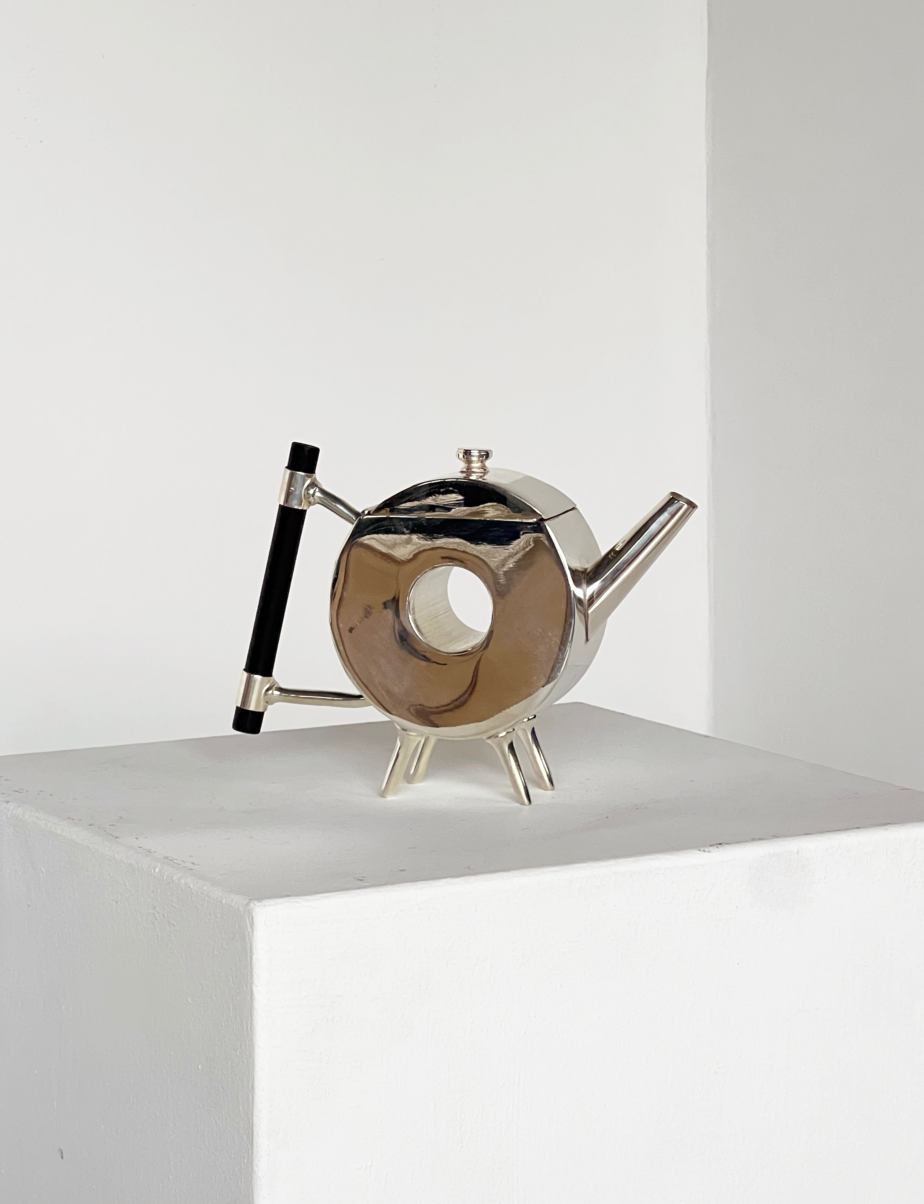 Christopher Dresser ornate circular teapot — top view on white pedestal