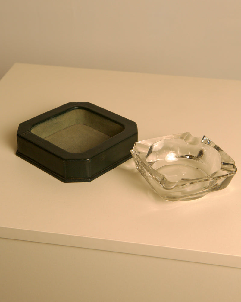 Forest green leather ashtray beside crystal glass ashtray detail