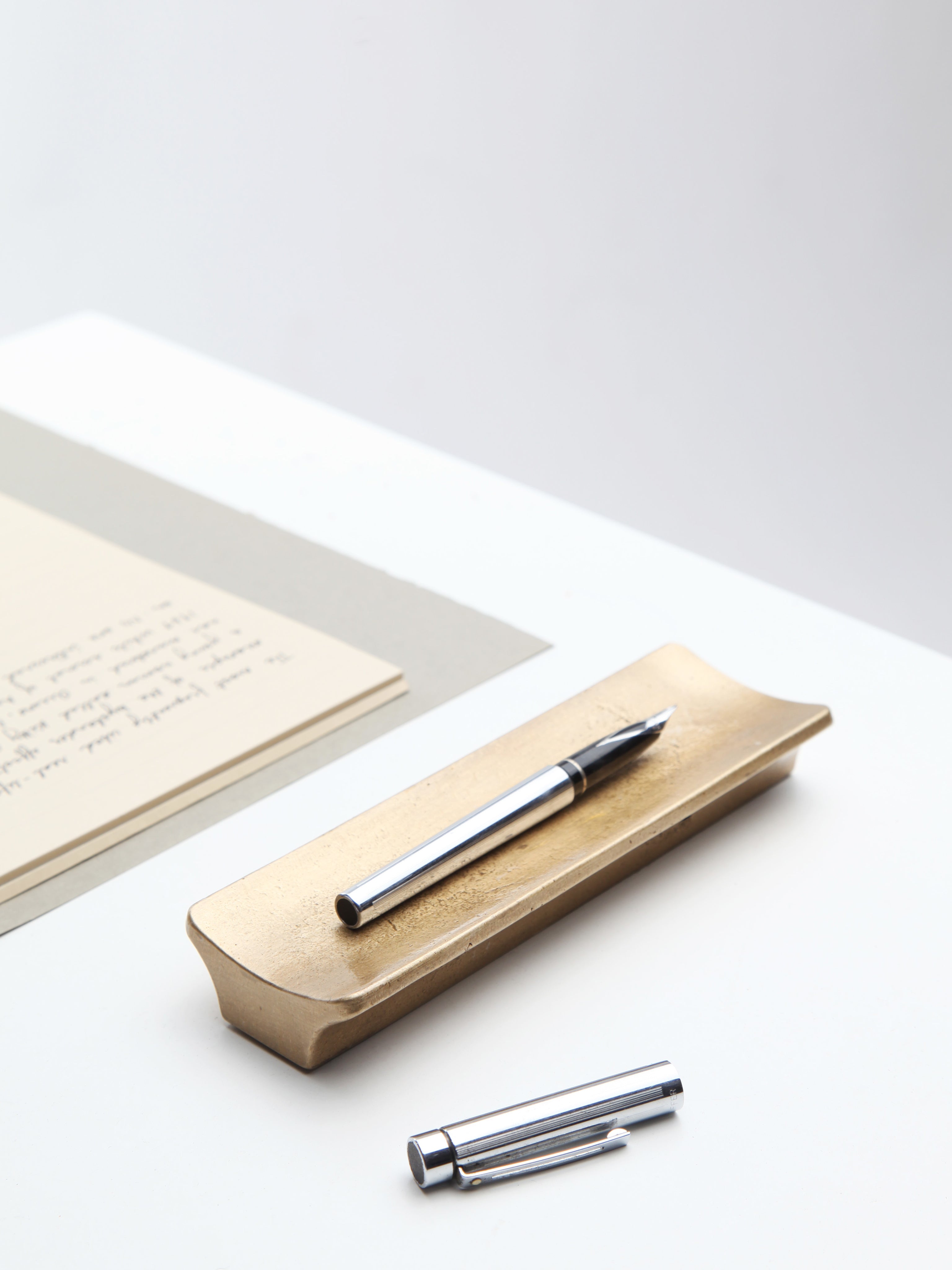 Arc Pen Tray — side angle showing brass finish with pen