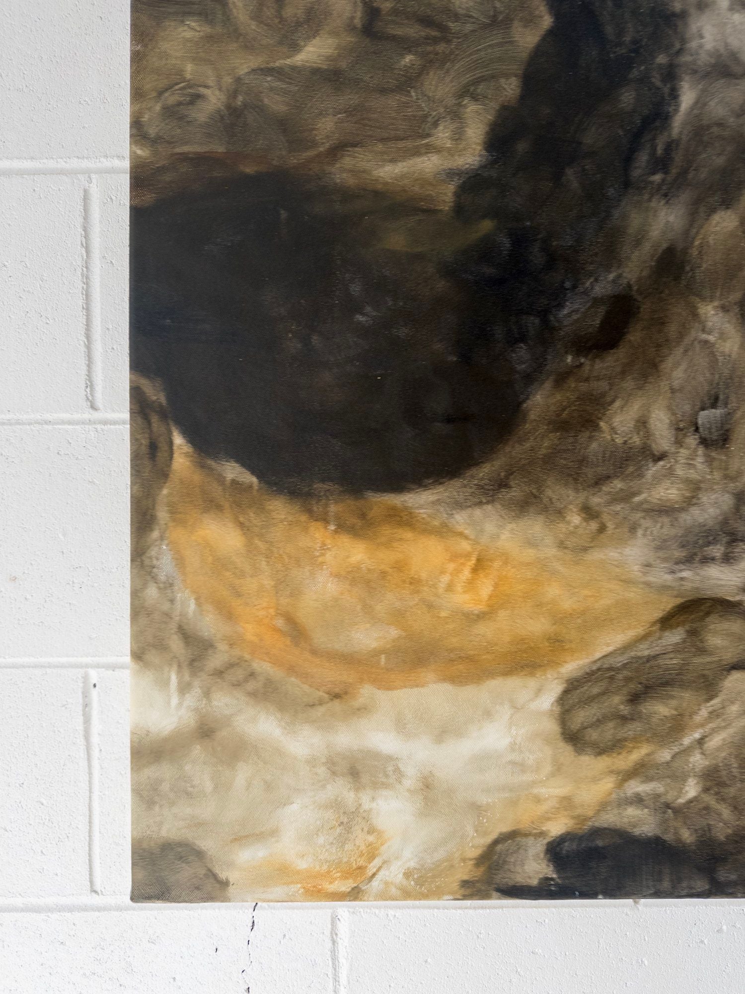 A close-up of “Bodies Entwined I” by Natasha France, an original mixed media on canvas artwork with earthy browns, blacks, ochres, and whites. Swirling brushstrokes form a textured pattern; partially hung on a white brick wall.