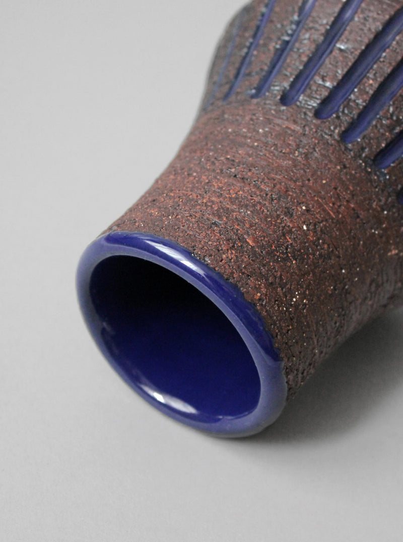 Textured ceramic vase interior detail with blue cobalt glaze rim