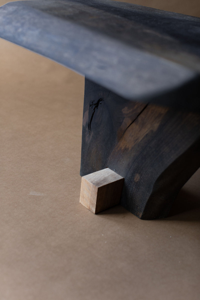 Qawha side table leg detail showing dark wood grain and joinery