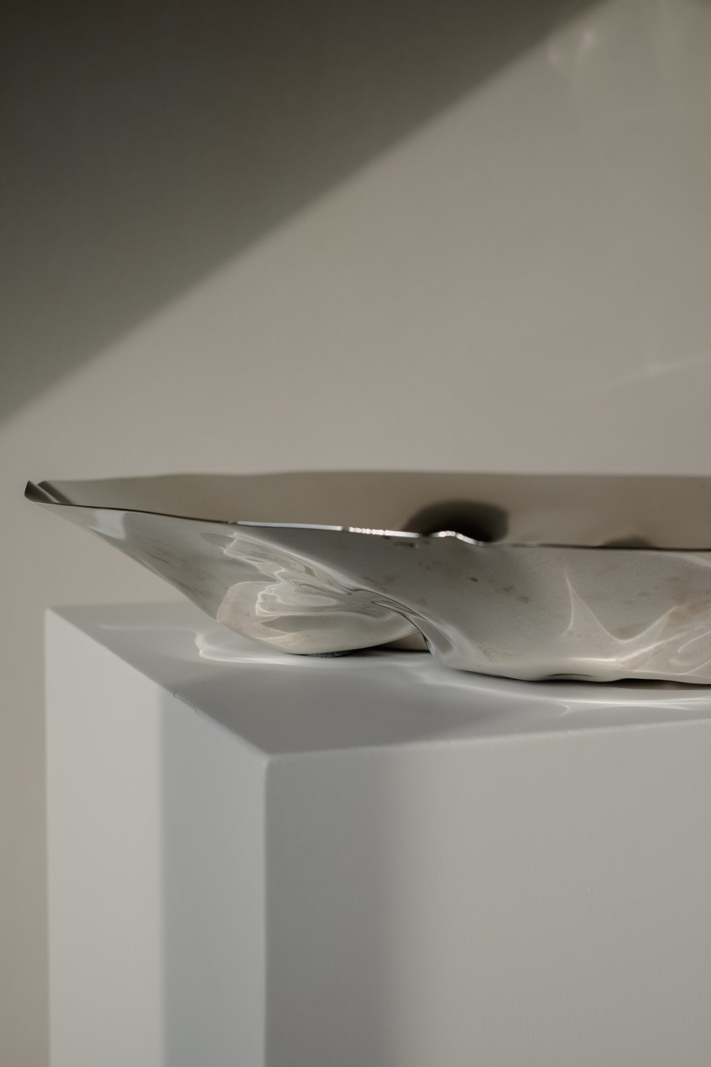 Chrome Curved Decorative Bowl — angled view highlighting shiny chrome finish