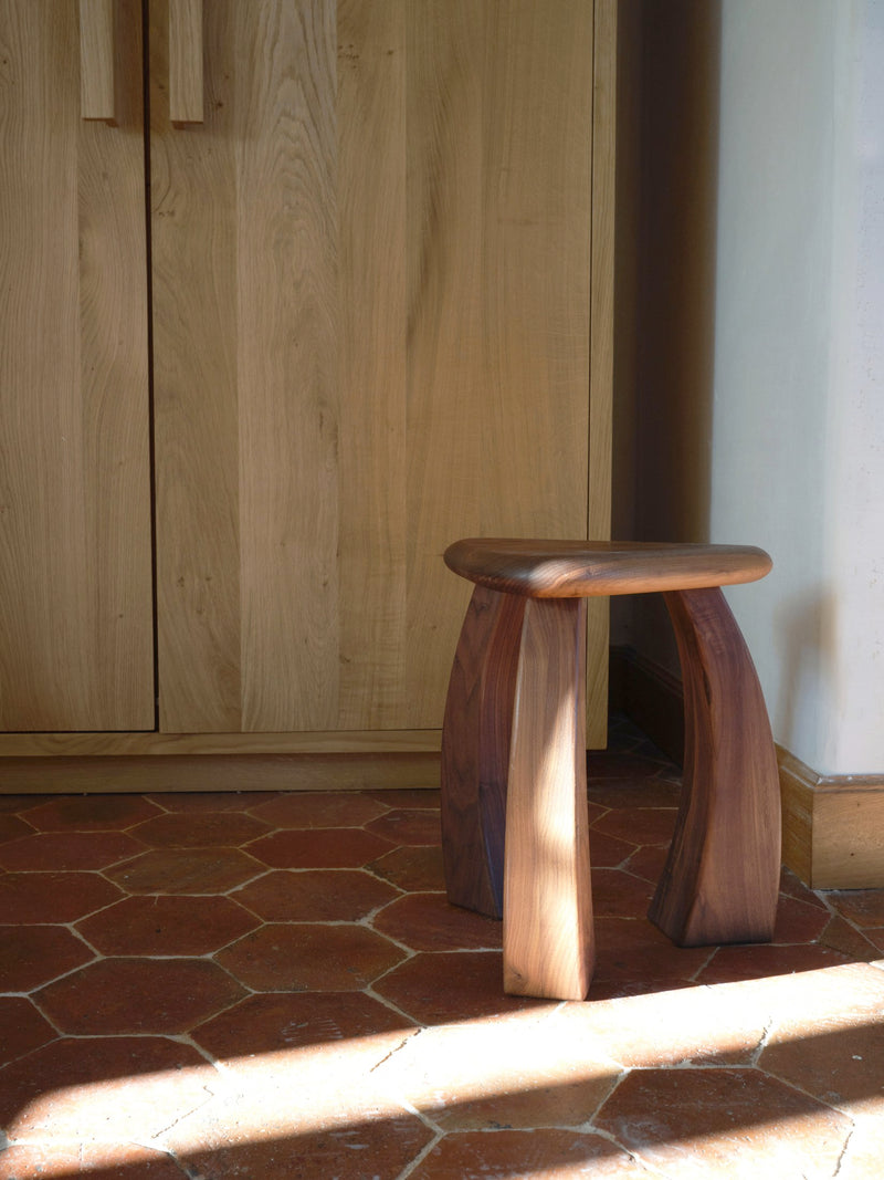 Arc de Stool '37 — close-up of wooden legs on tiled floor