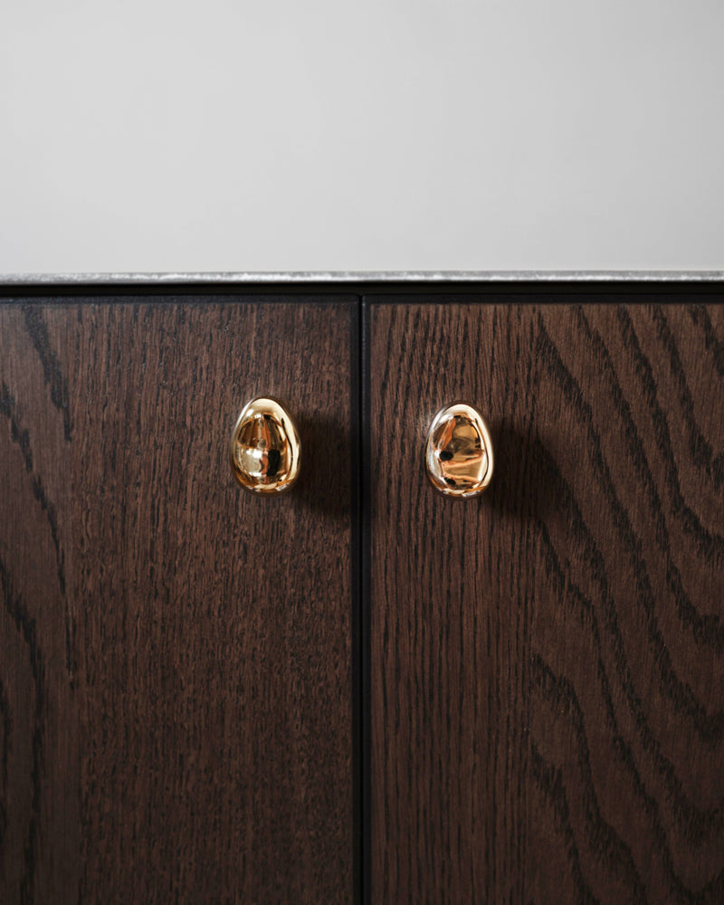 Rud Knob - Brass — close-up of brass knob on dark wood cabinet