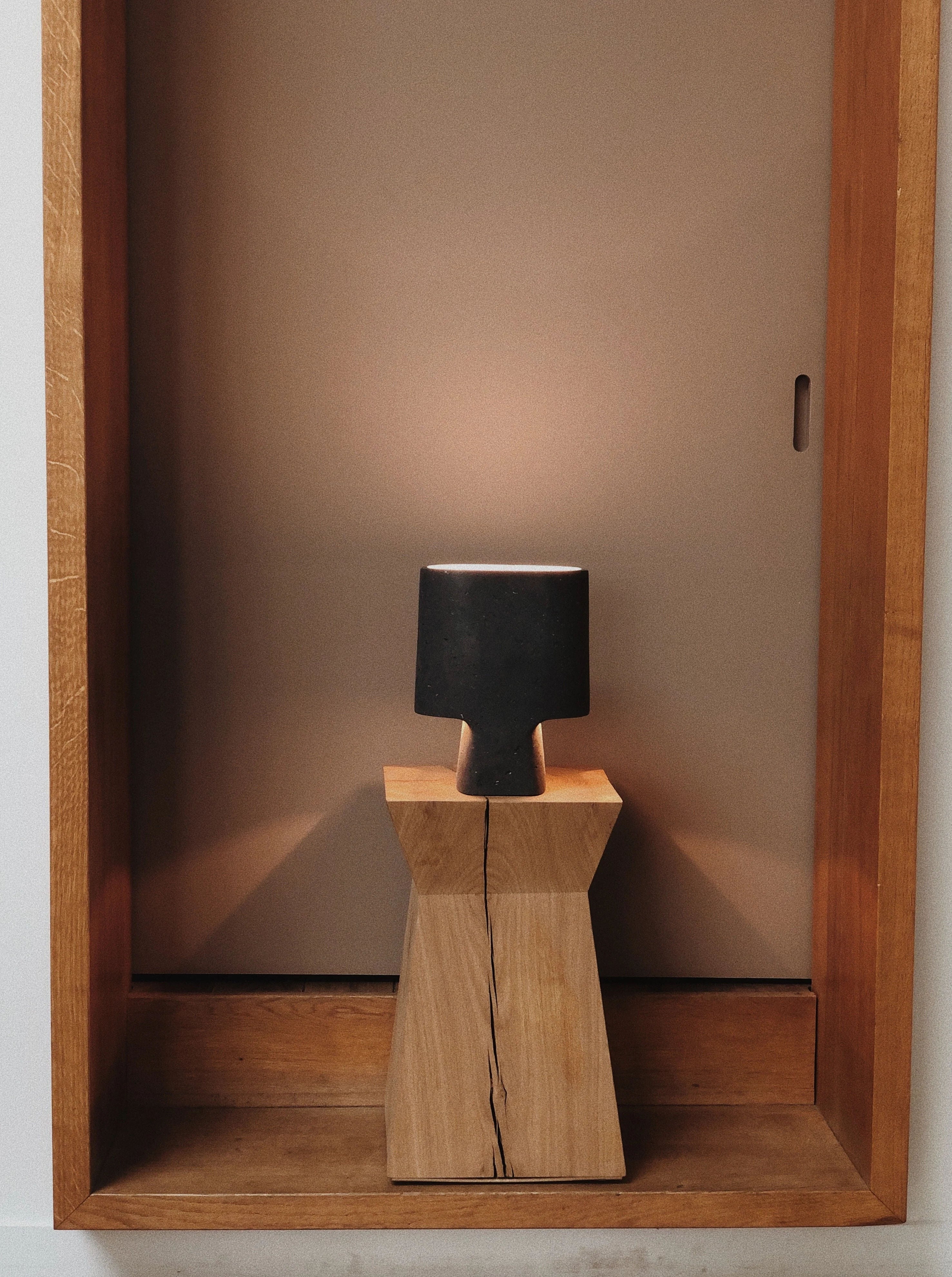 The Lamp Bien Faite Anthracite — side angle in wooden niche