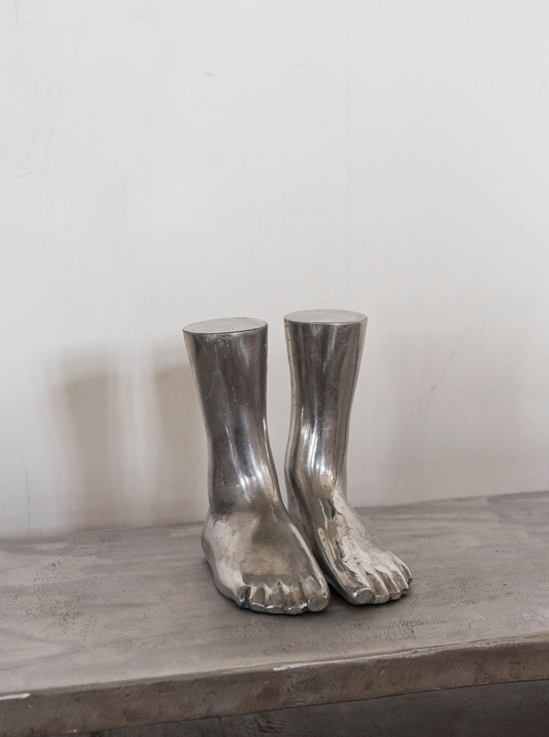 Aluminum Feet Sculpture — close-up of polished aluminum surface on table