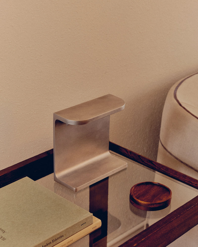 The Standard' Desk Lamp — close-up of brushed metal base on glass table