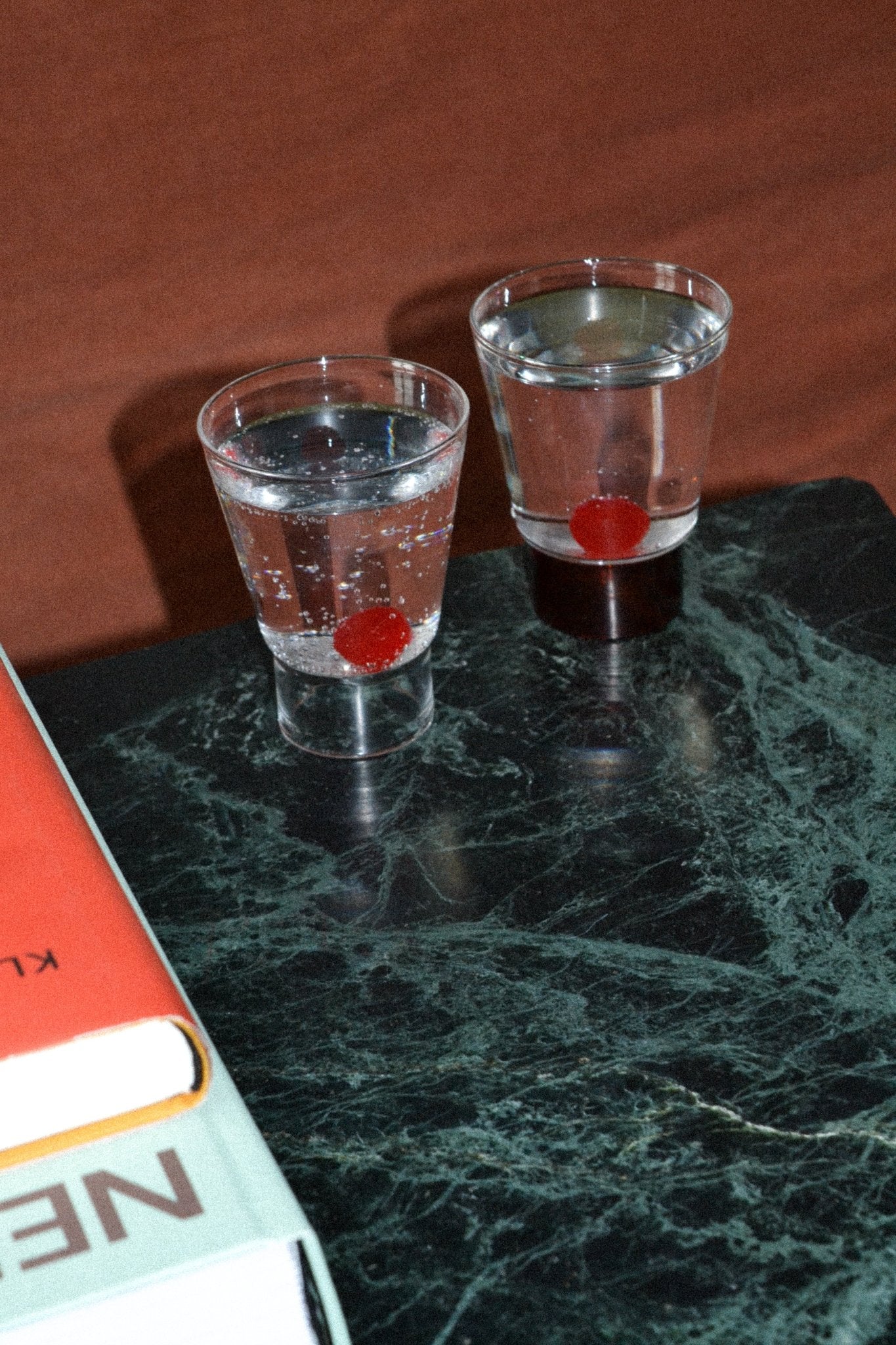 Podio' Glass - Amber — back view on marble table with drinks
