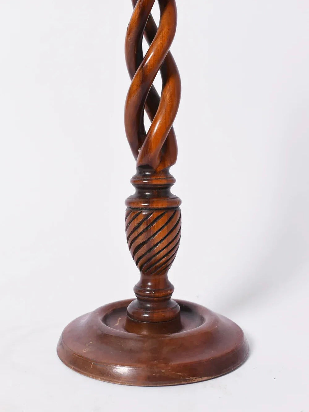 A close-up of a Pair of Turned Wood Candlesticks, 19th c. by Barracuda Interiors, featuring round bases and intricately spiral-carved columns, set against a plain white background.