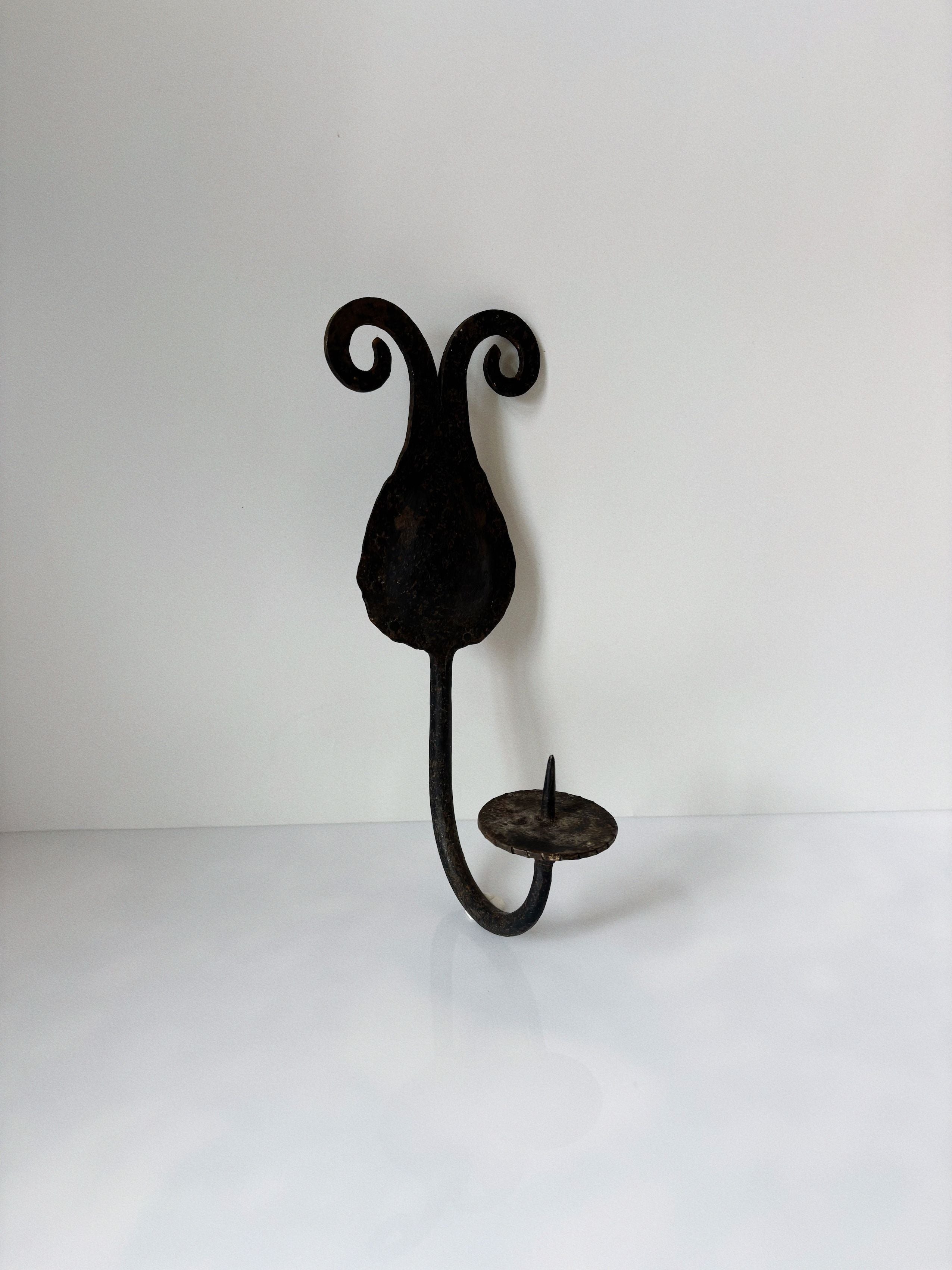 Hand-forged iron wall sconce with curved scrollwork detail