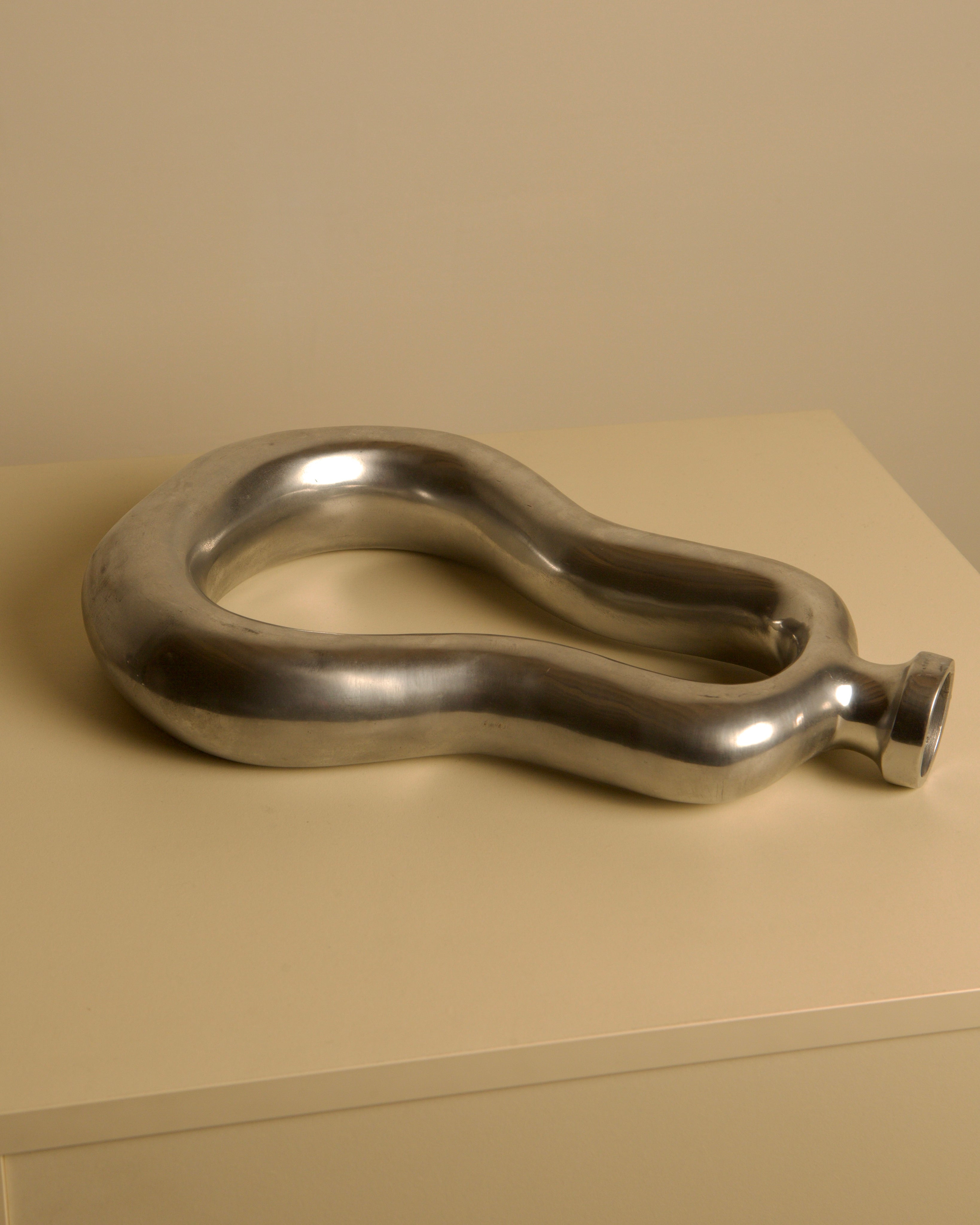 Italian cast aluminum vase 80's — angled view on neutral surface