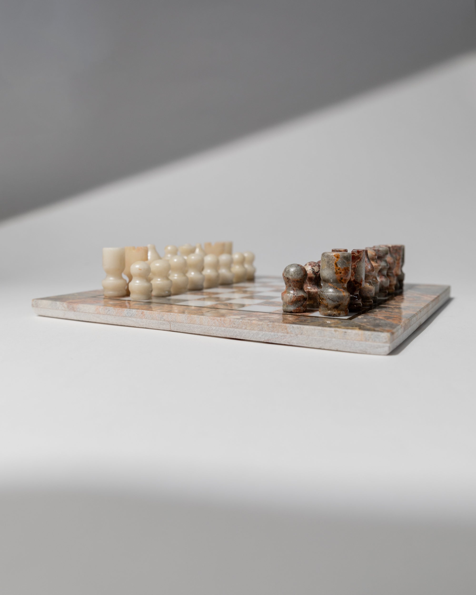Vintage marble chess set positioned on checkered board, Italy 1960s