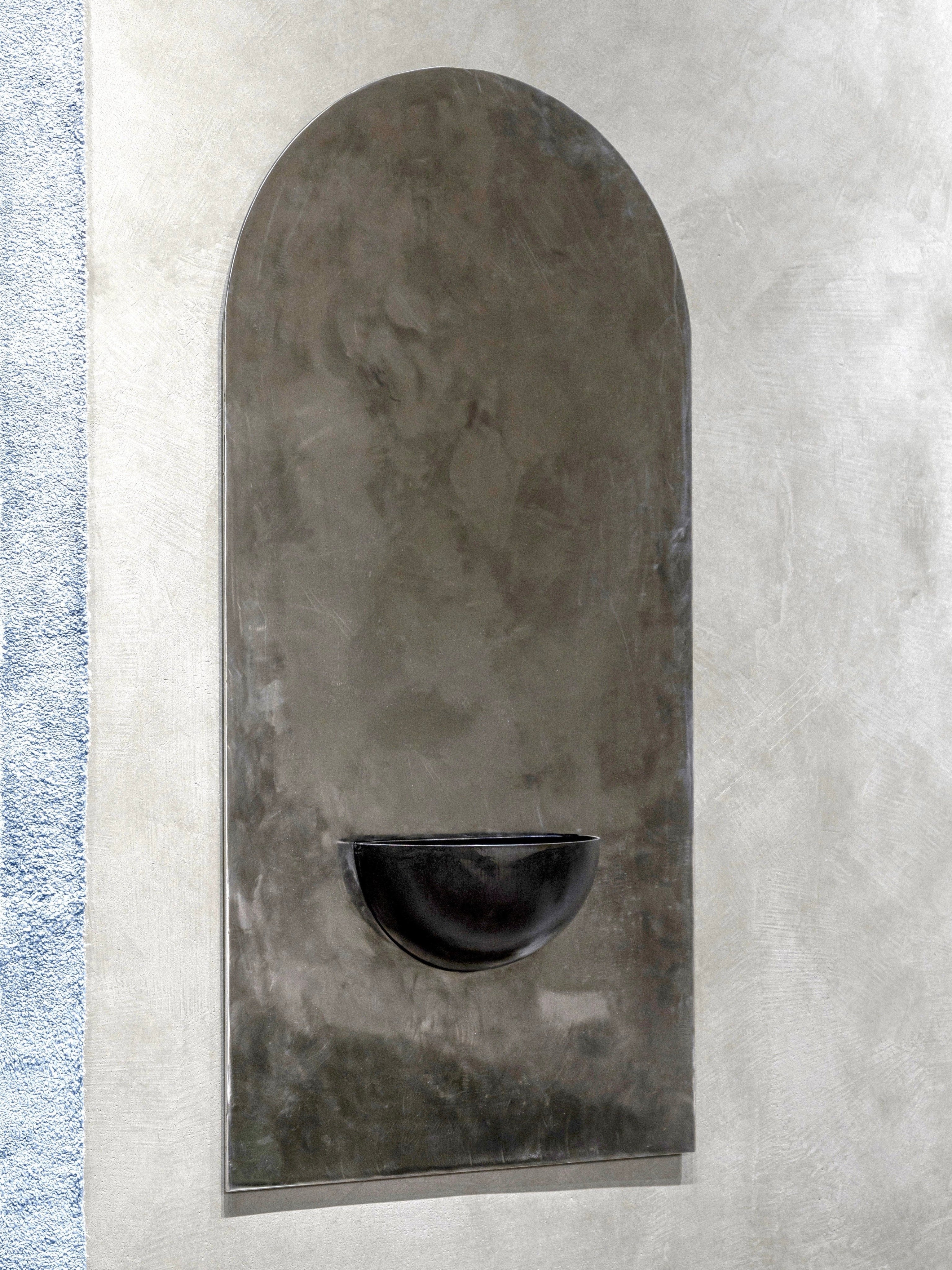 The Mirror of Simple Souls (Large) - Contemporary Mirror in Steel — top view showing curved black basin against textured wall