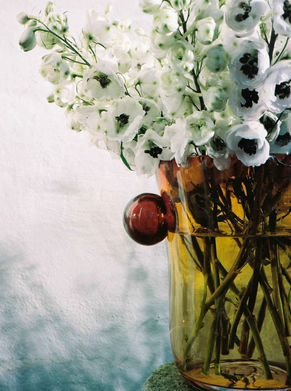 Mouthblown Oliver Vase — close-up of amber glass with flowers