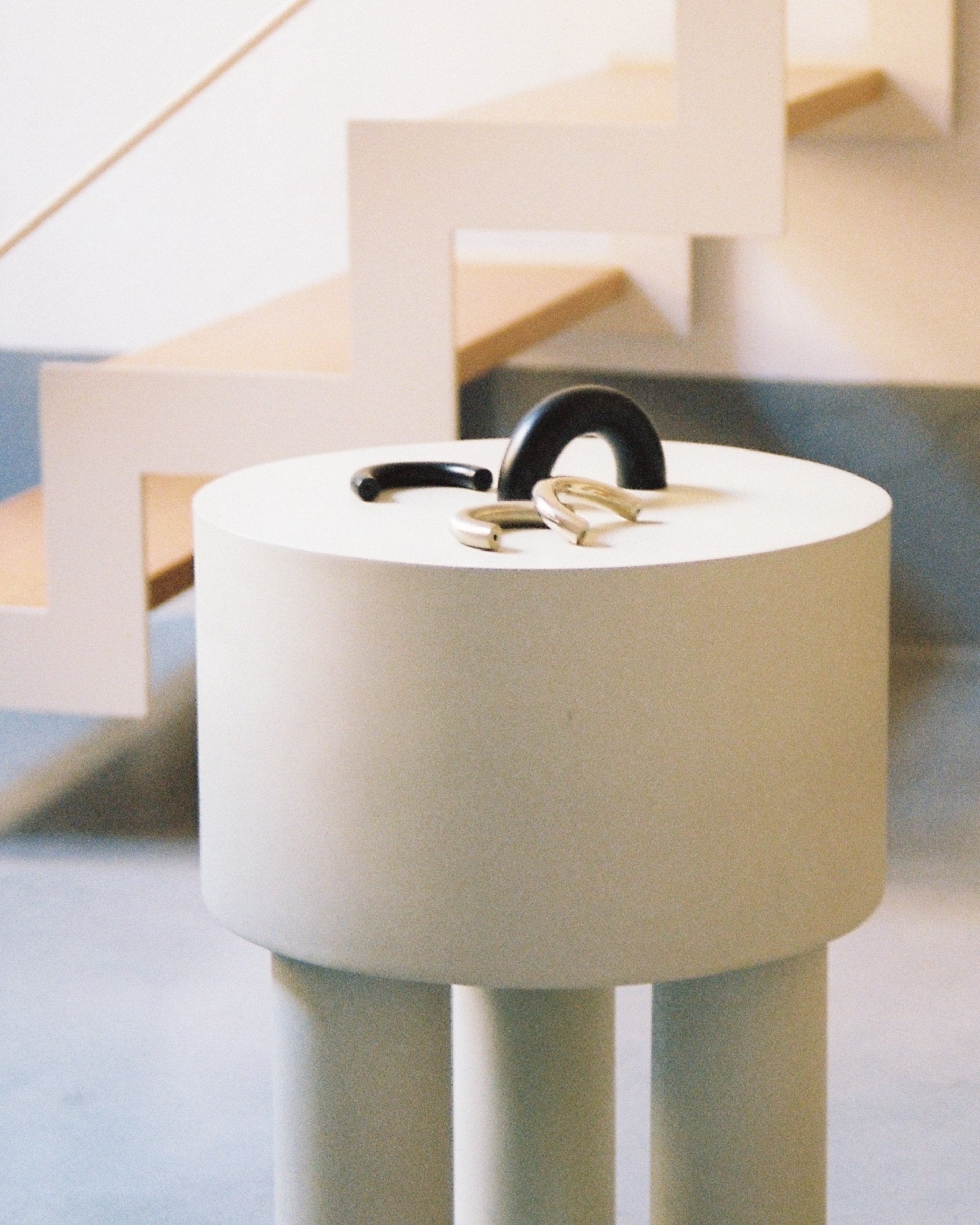 CERCLE Cabinet Pull Thin (2 sizes) — side view on minimalist round pedestal