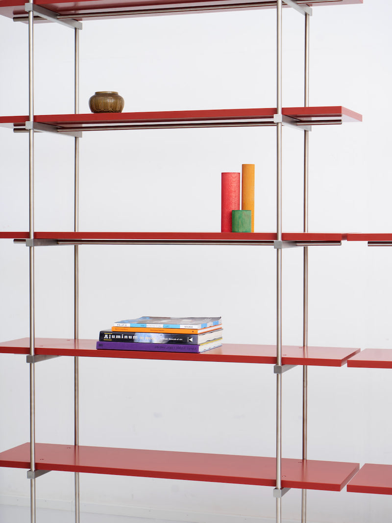 Spaghetti Shelf System — close-up of red metal shelves with decor