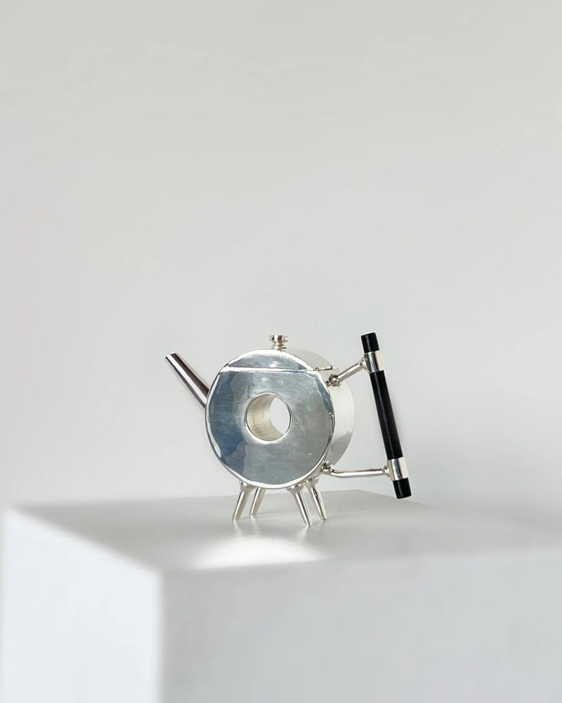 Christopher Dresser ornate circular teapot — close-up of polished metal surface
