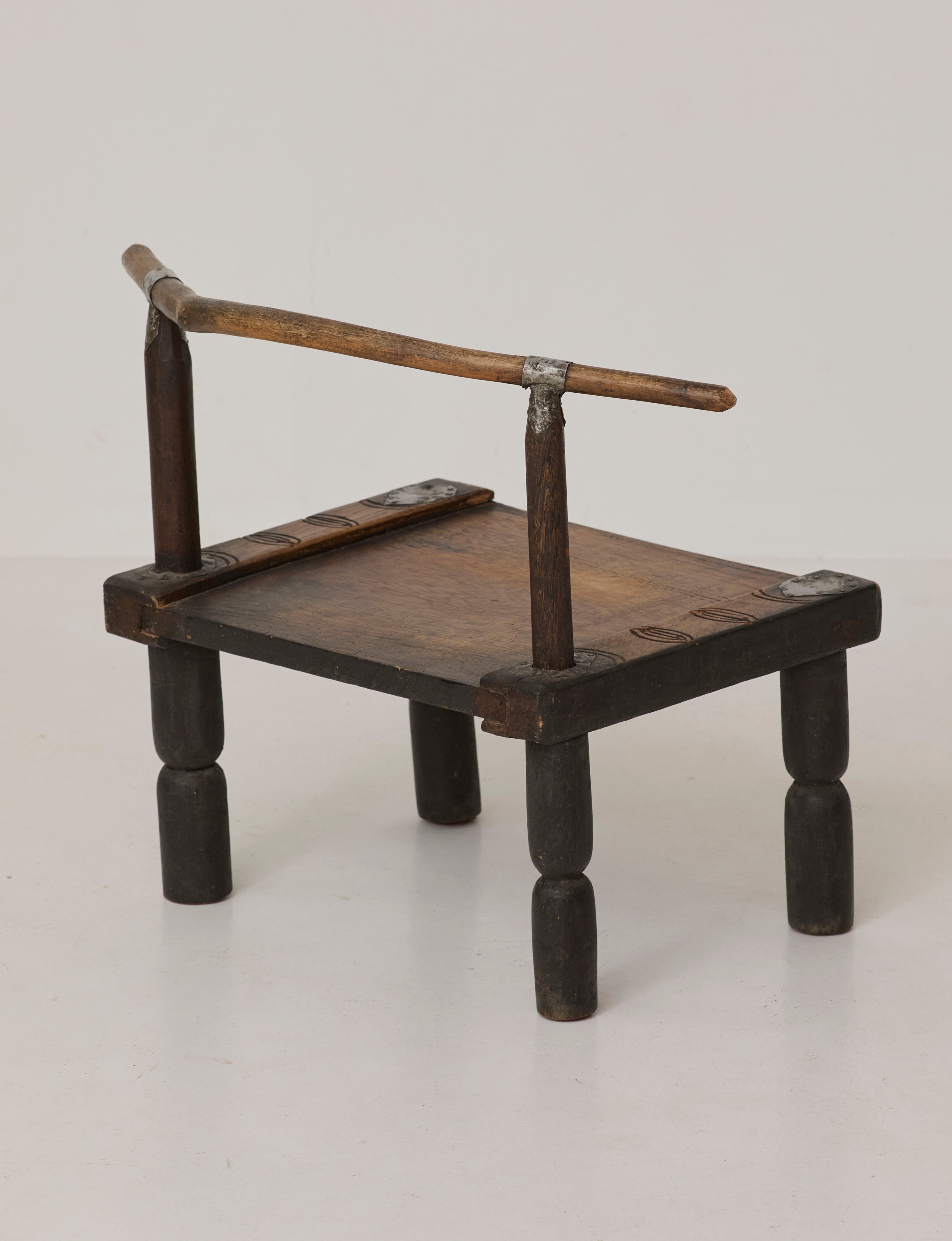 Small artisanal vintage West African chair "Baoulé" in solid wood C. 1960 — lifestyle setting