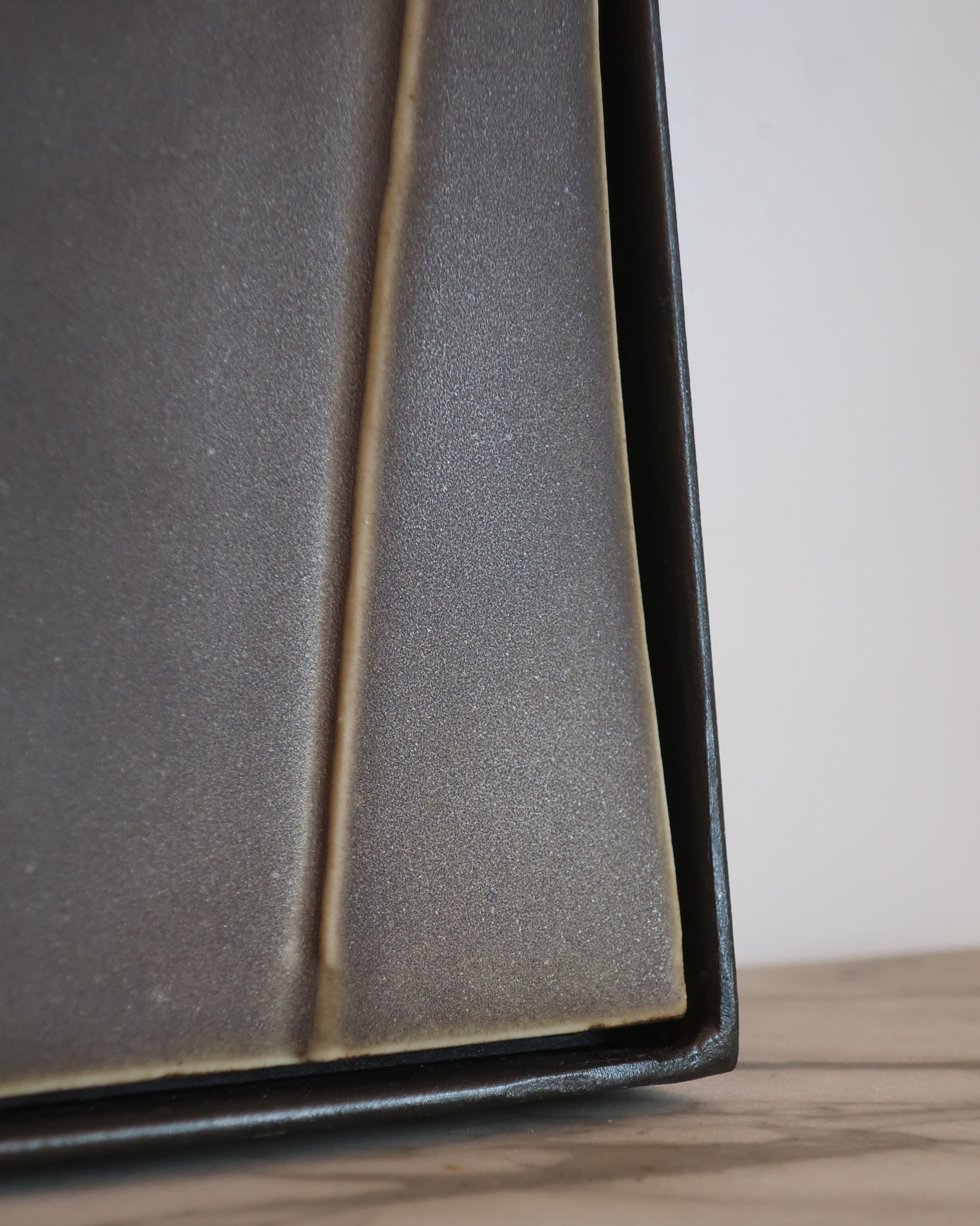 Profile detail of GIO I mirror's angular bronze frame edge