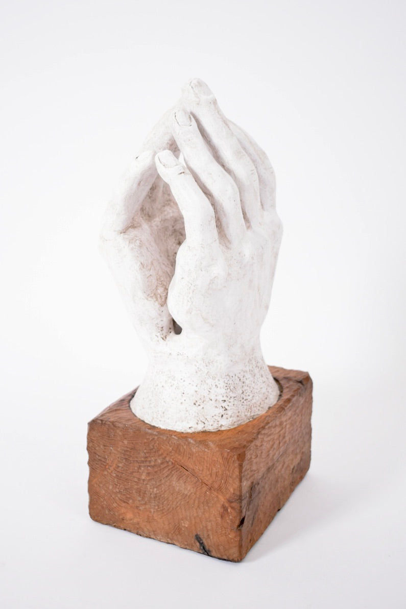 Rodin Style Plaster and Wood Sculpture, 1960s by Barracuda Interiors: Features two white hands in a meditative pose on a square wooden base, inspired by Rodin, shown against a plain white background.