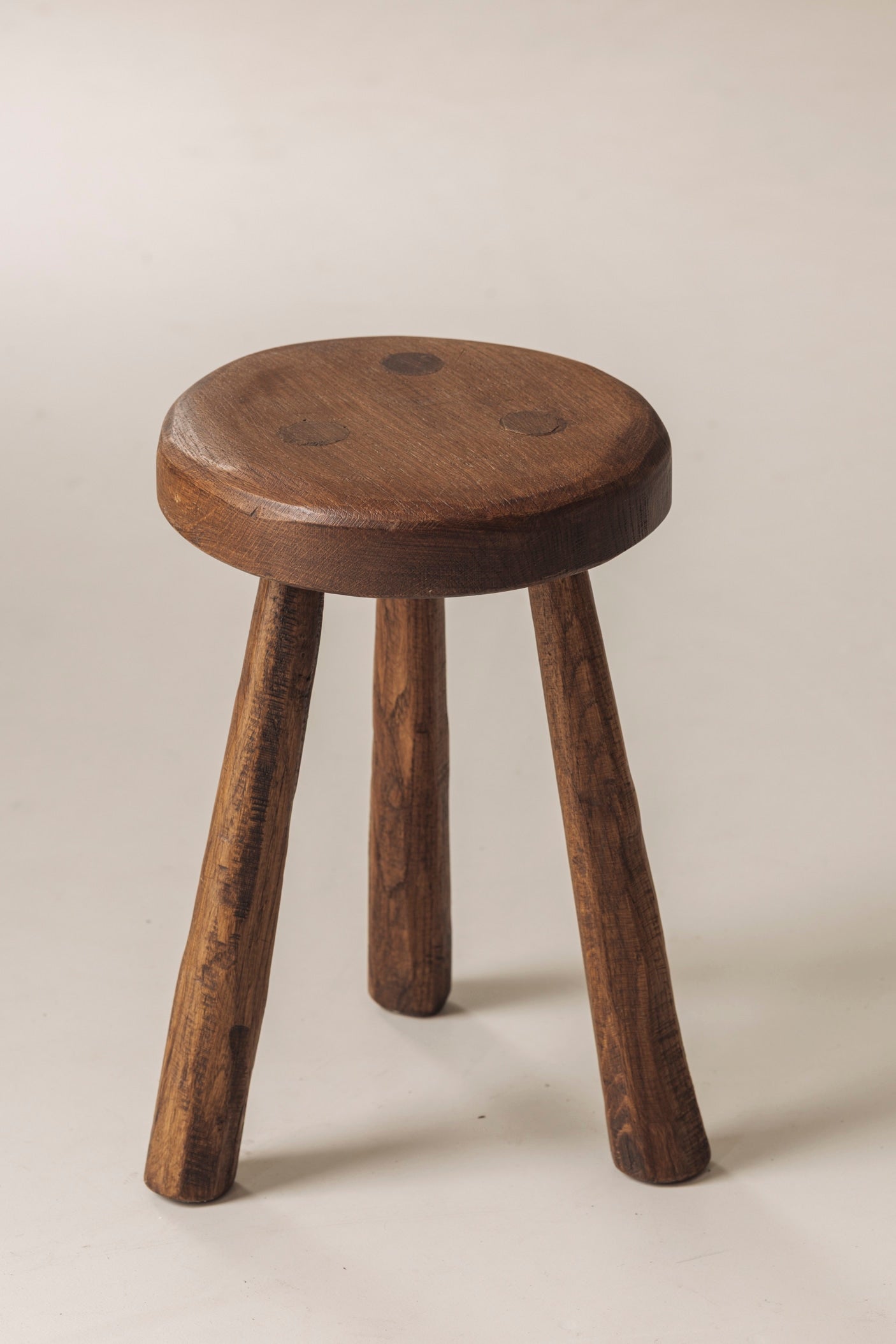 Set of two solid elm tripod stools from France, 1950s — lifestyle setting