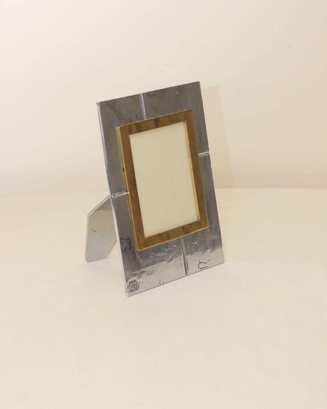 Brutalist Portrait Holder — close-up of metallic frame with brass accent