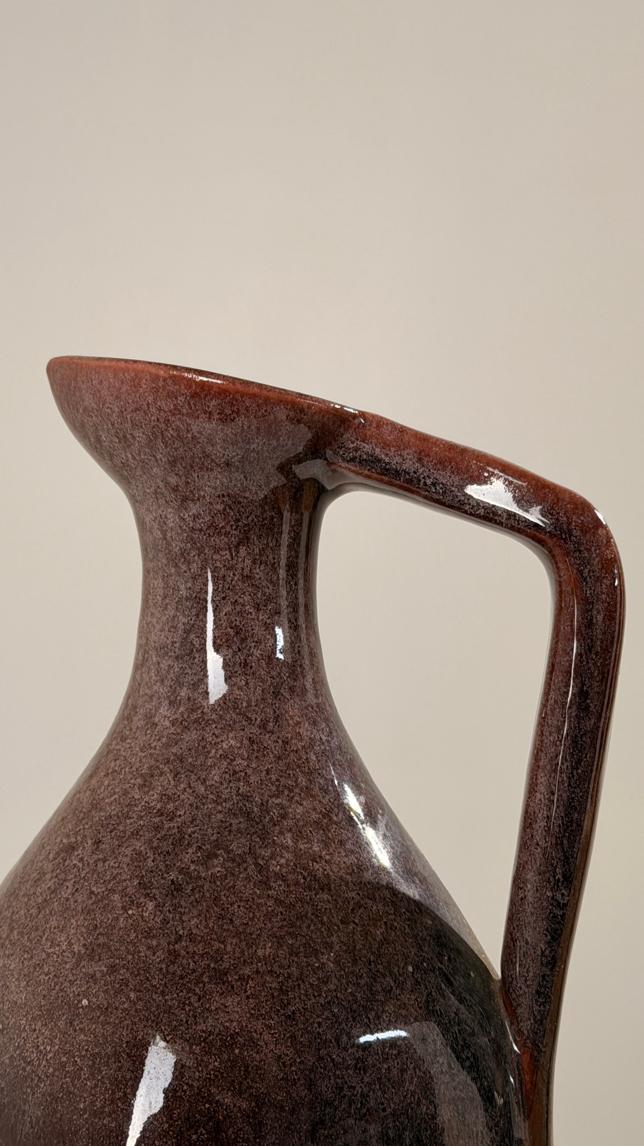 Ceramic pitcher by the Accolay potters, France, circa 1960 — close-up of glossy brown ceramic surface