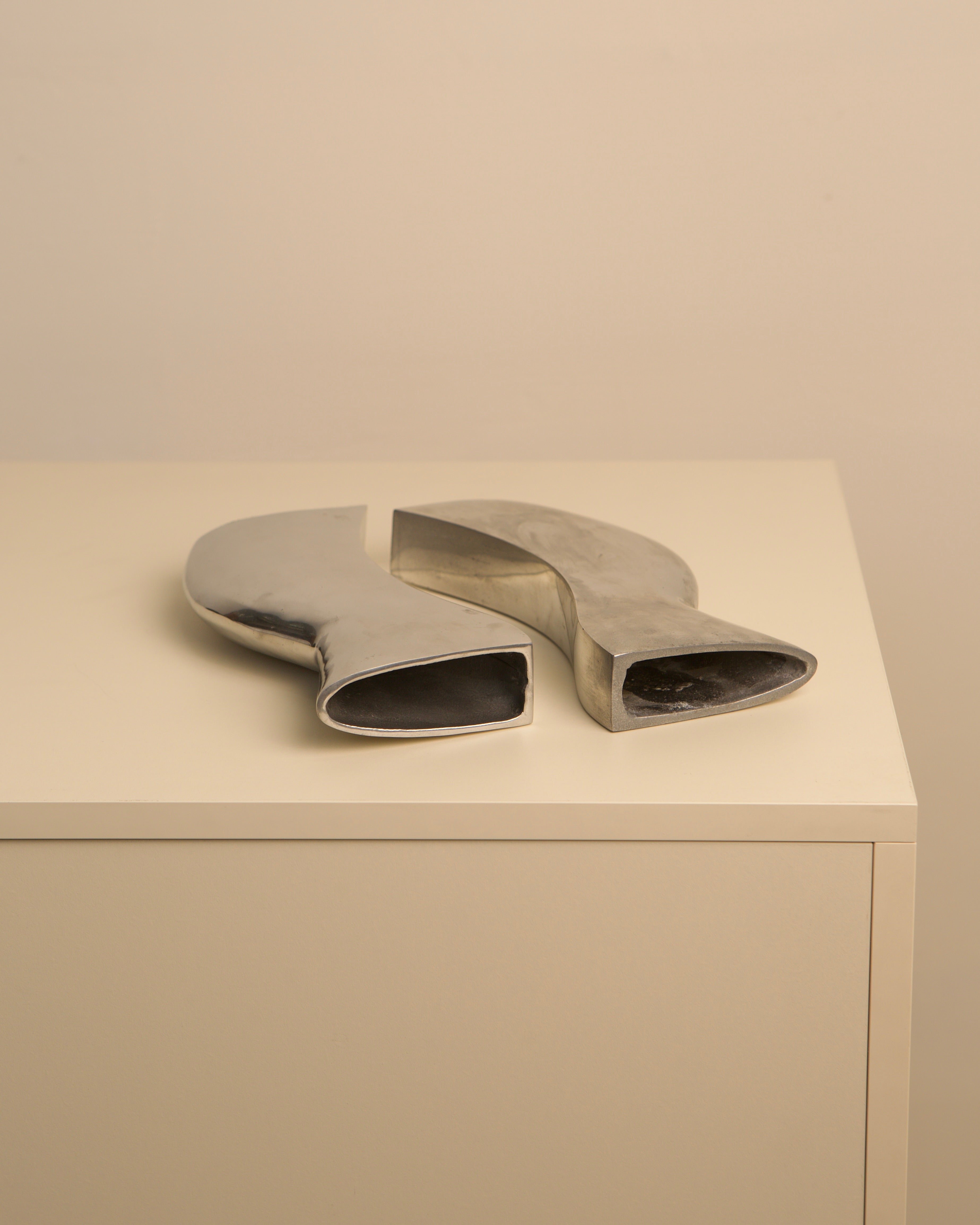 Two curved aluminum Dance vases displaying modern sculptural forms