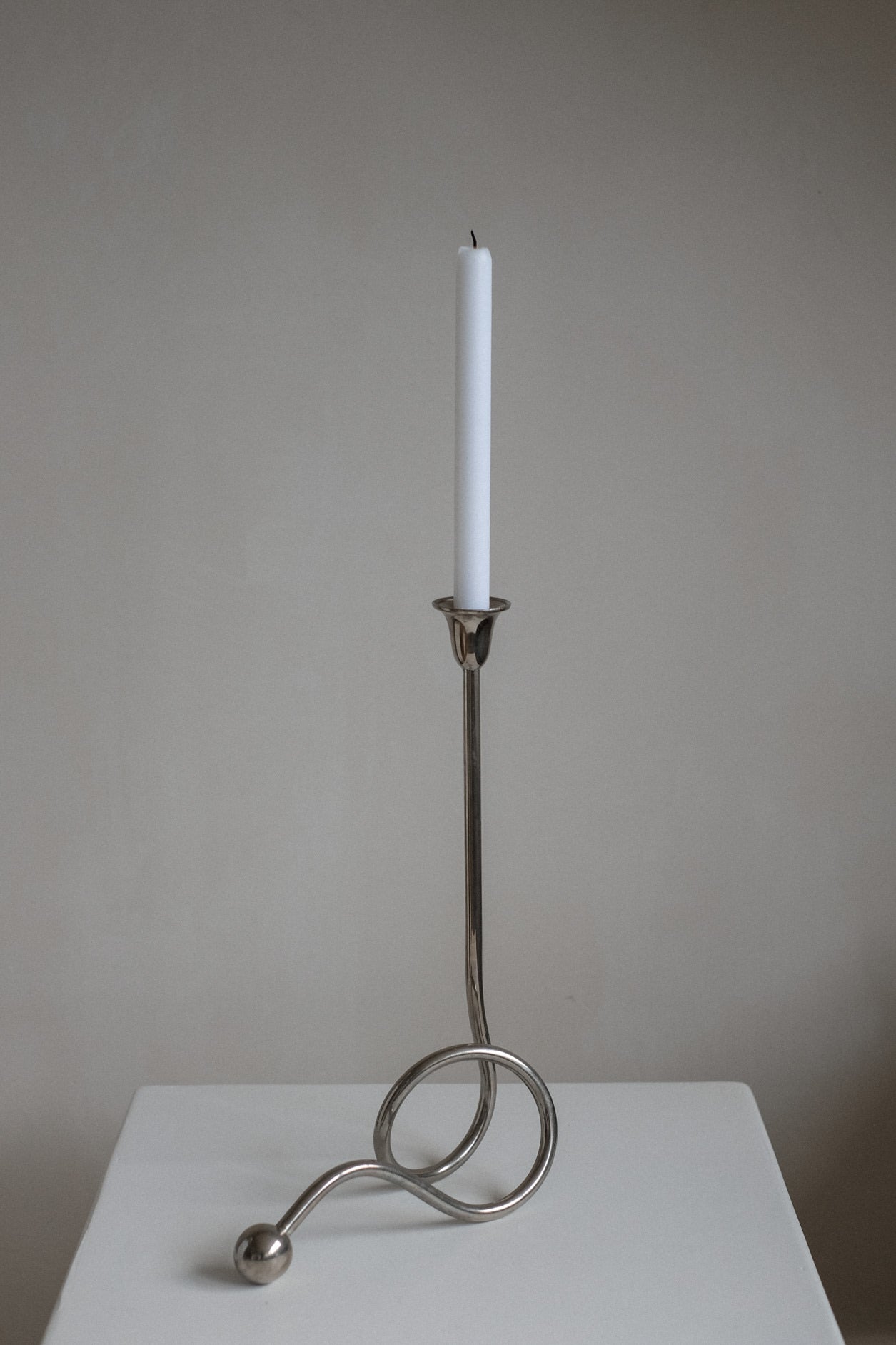Chrome Candle Holder by Guido Niest — side view on white surface