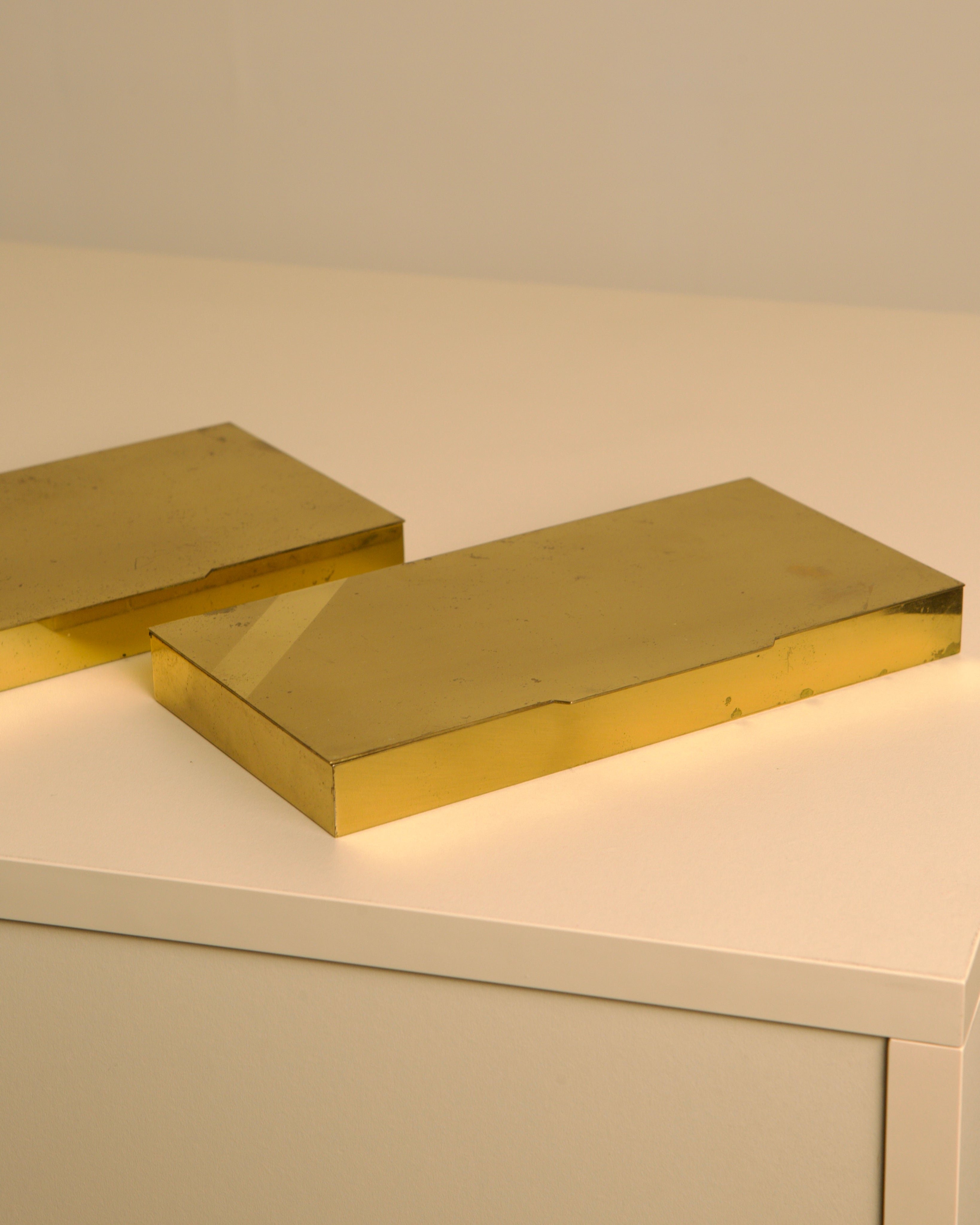 Close-up view of Italian brass and wood boxes showing golden finish