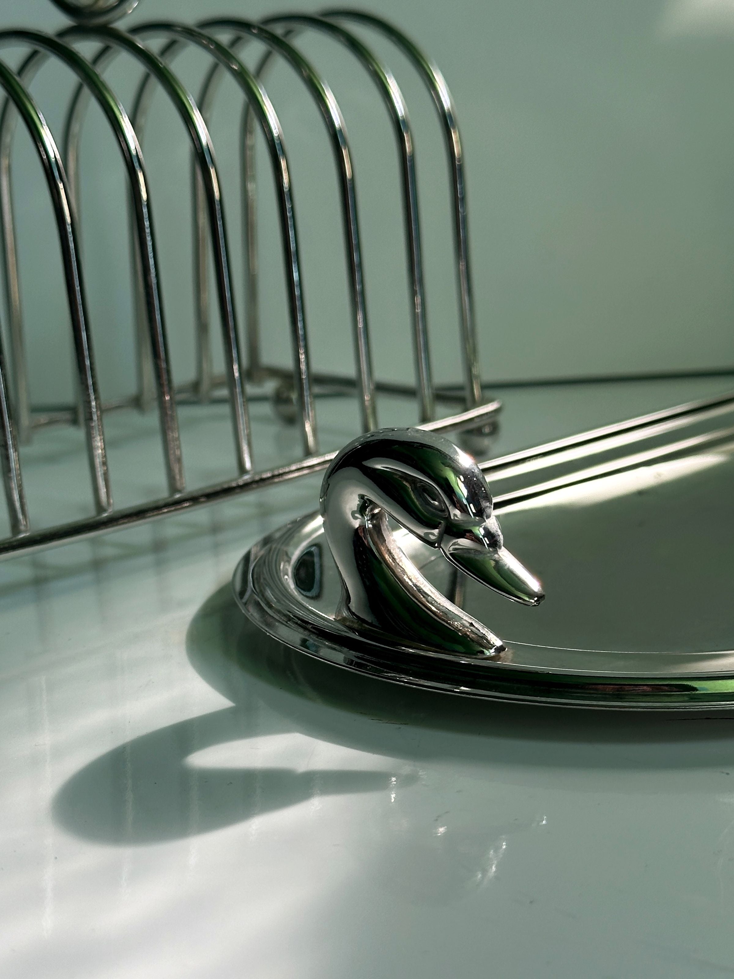 Silver-plated tray with curved toast rack showing reflective detail