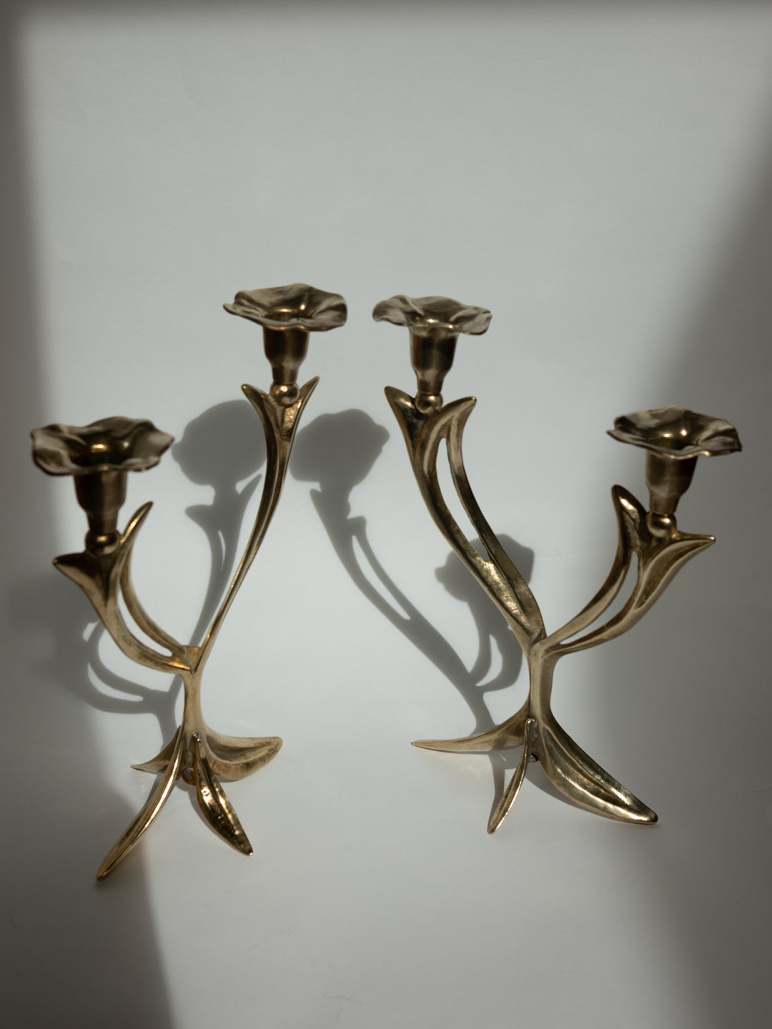 Pair of Sculptural Solid Brass Candlesticks, Floral Form - France, c. 1960s — angled view highlighting floral design and shad