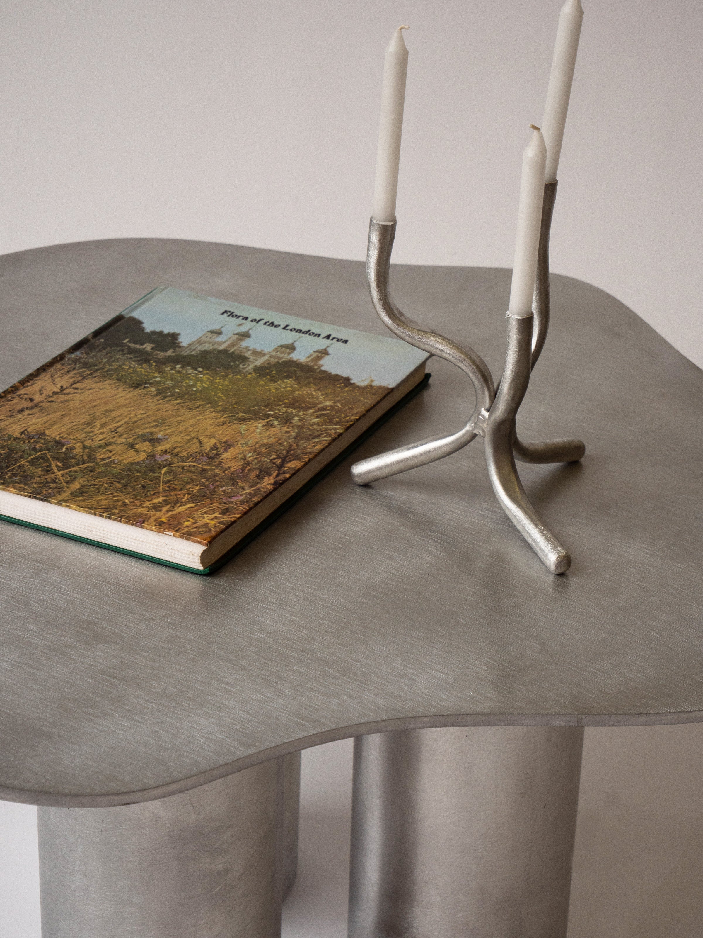 Aluminium Coffee Table — side angle with book and candle holder