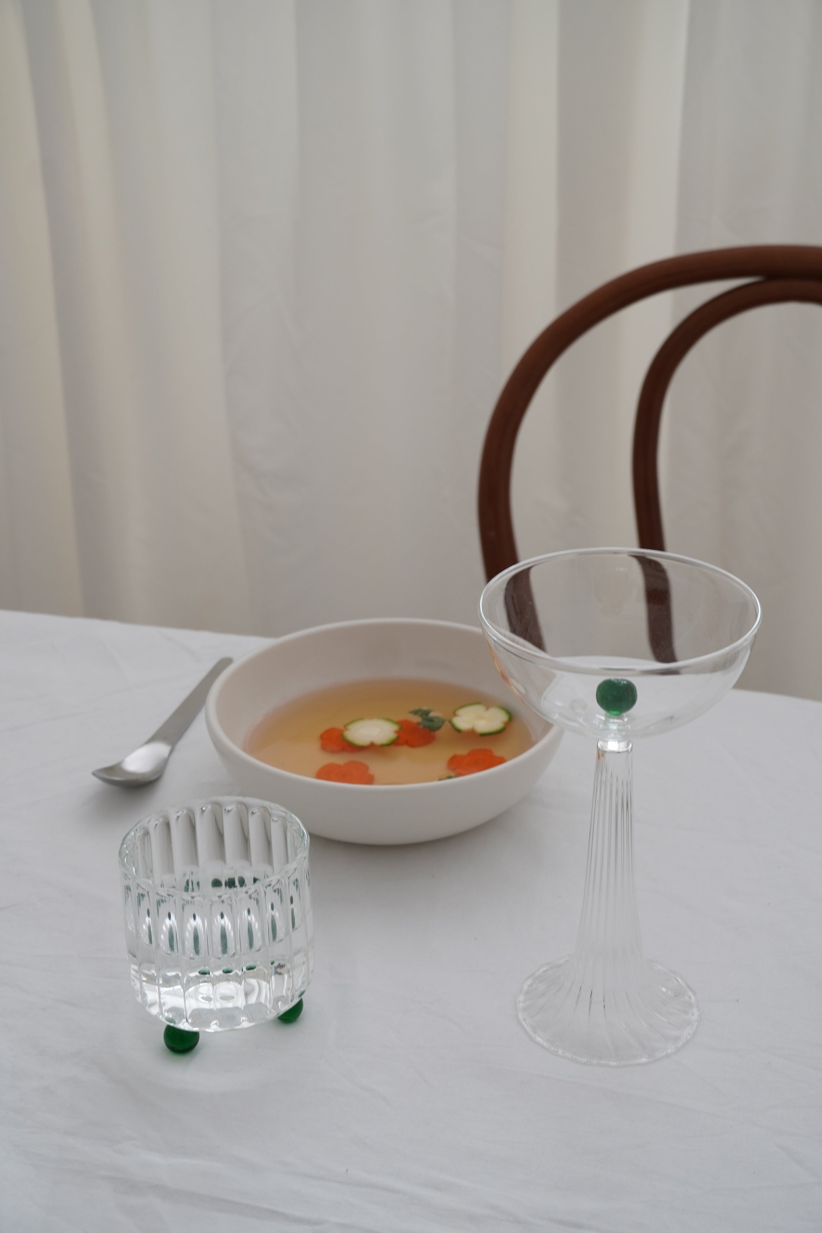 High Spirits — Lowball Glass Green — side view on dining table with soup bowl