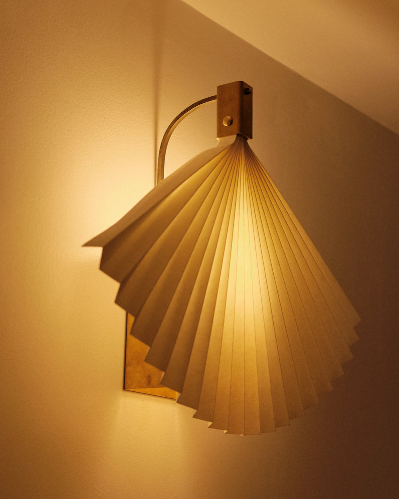 Modern pleated wood wall sconce with warm lighting by Policronica