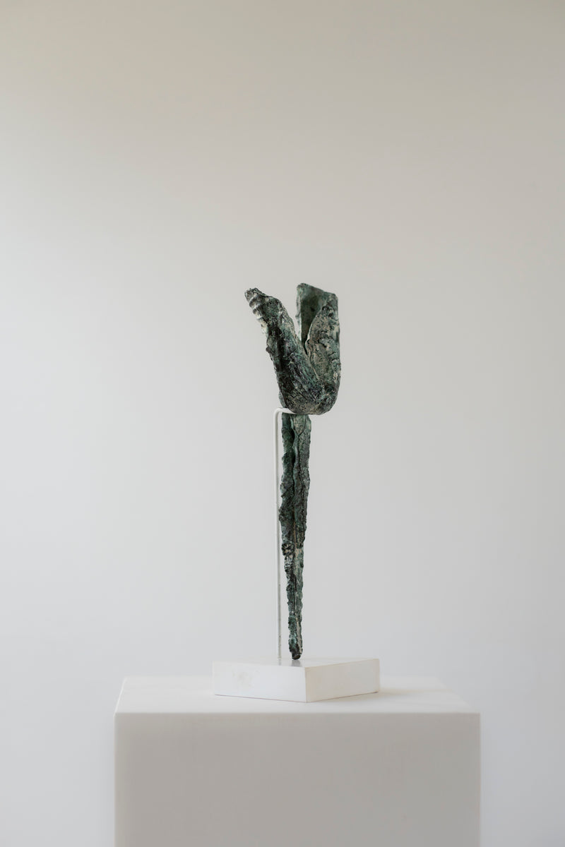 Ancient bronze harpoon sculpture on white display stand detail