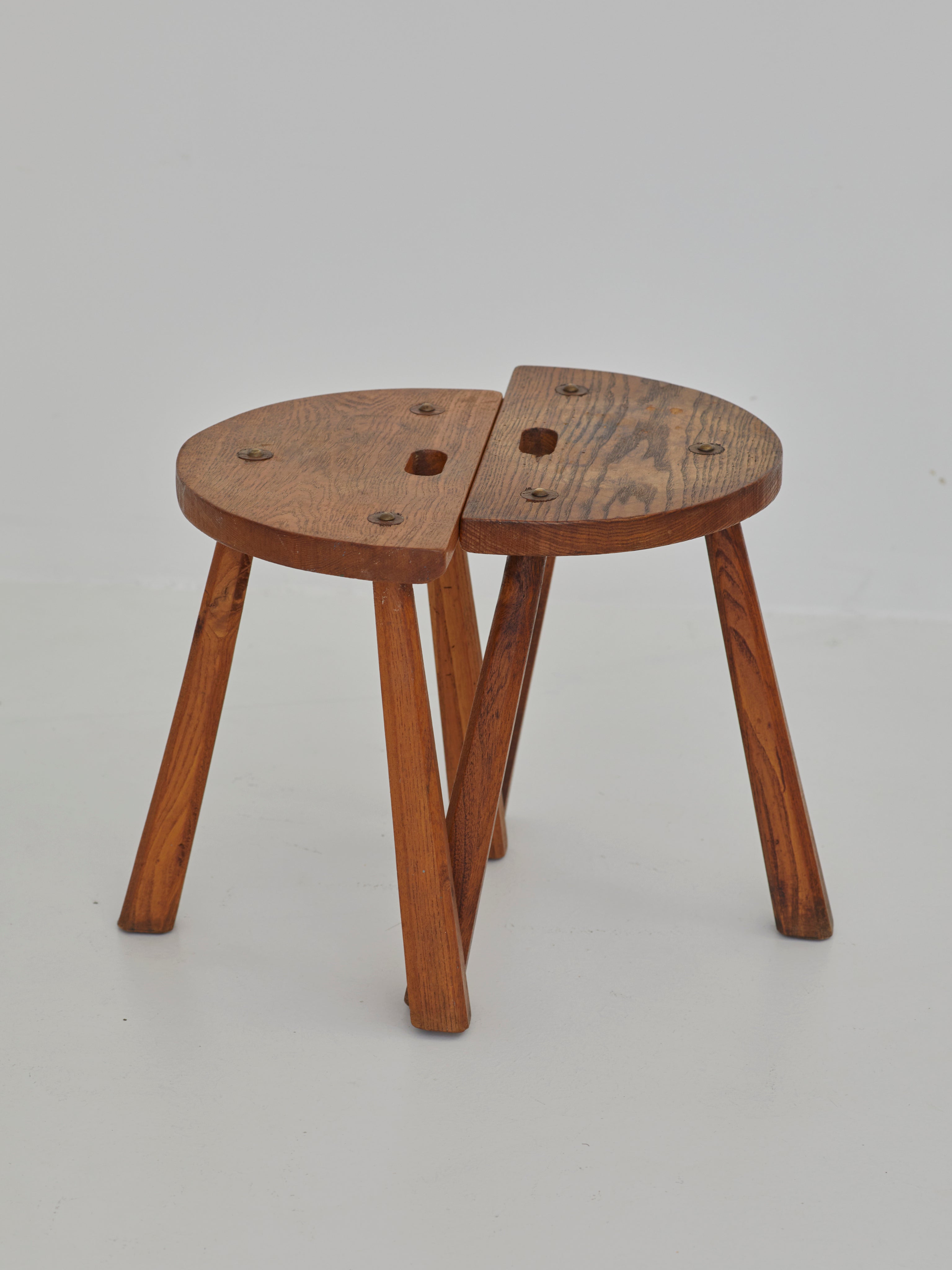 Two French Artisanal Solid Wood Half-moon Tripod Stools, Circa 1950 — angled view highlighting wooden legs and seat