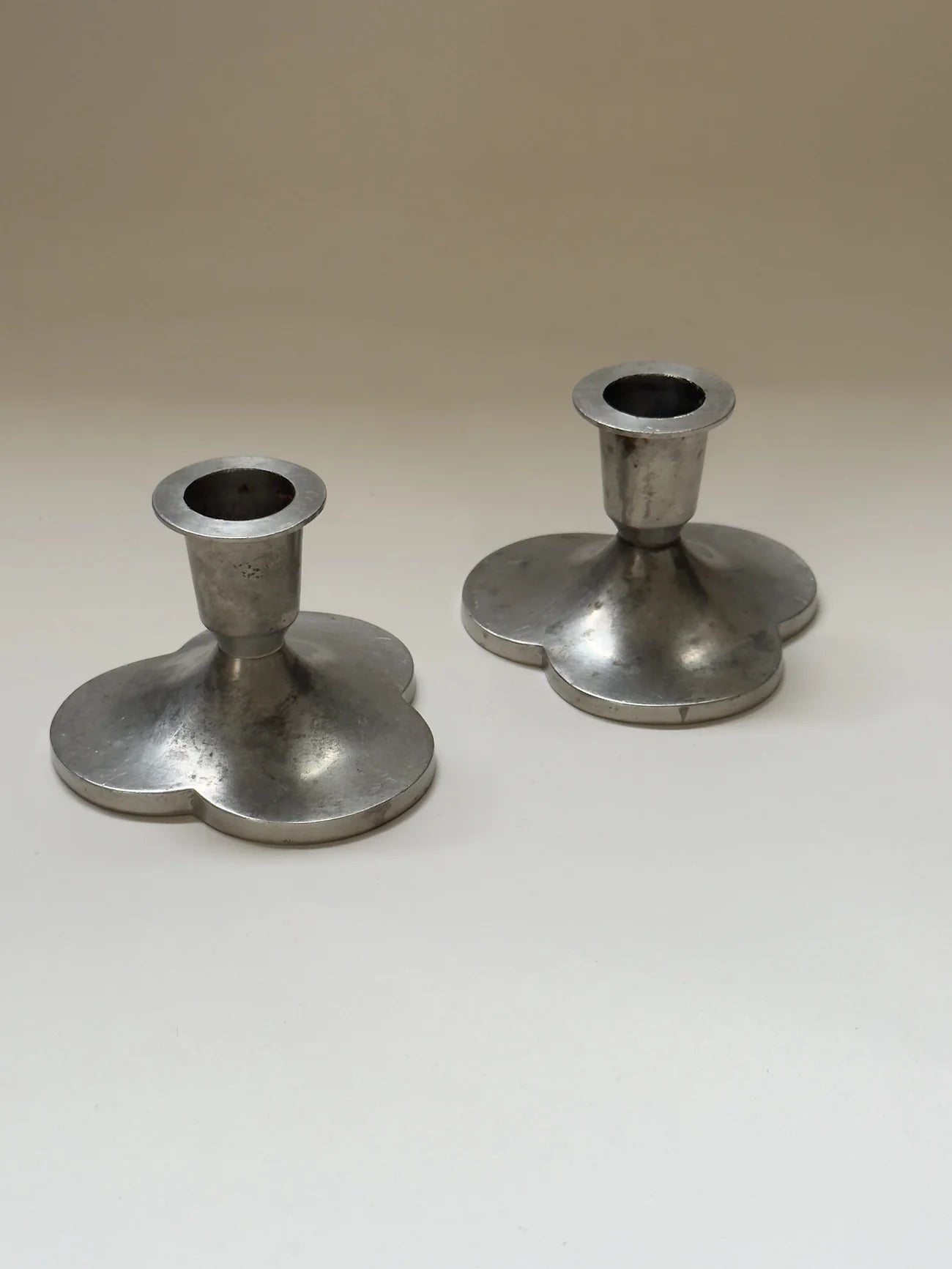 Pair of Pewter Candlesticks by Just Andersen — angled view on neutral background