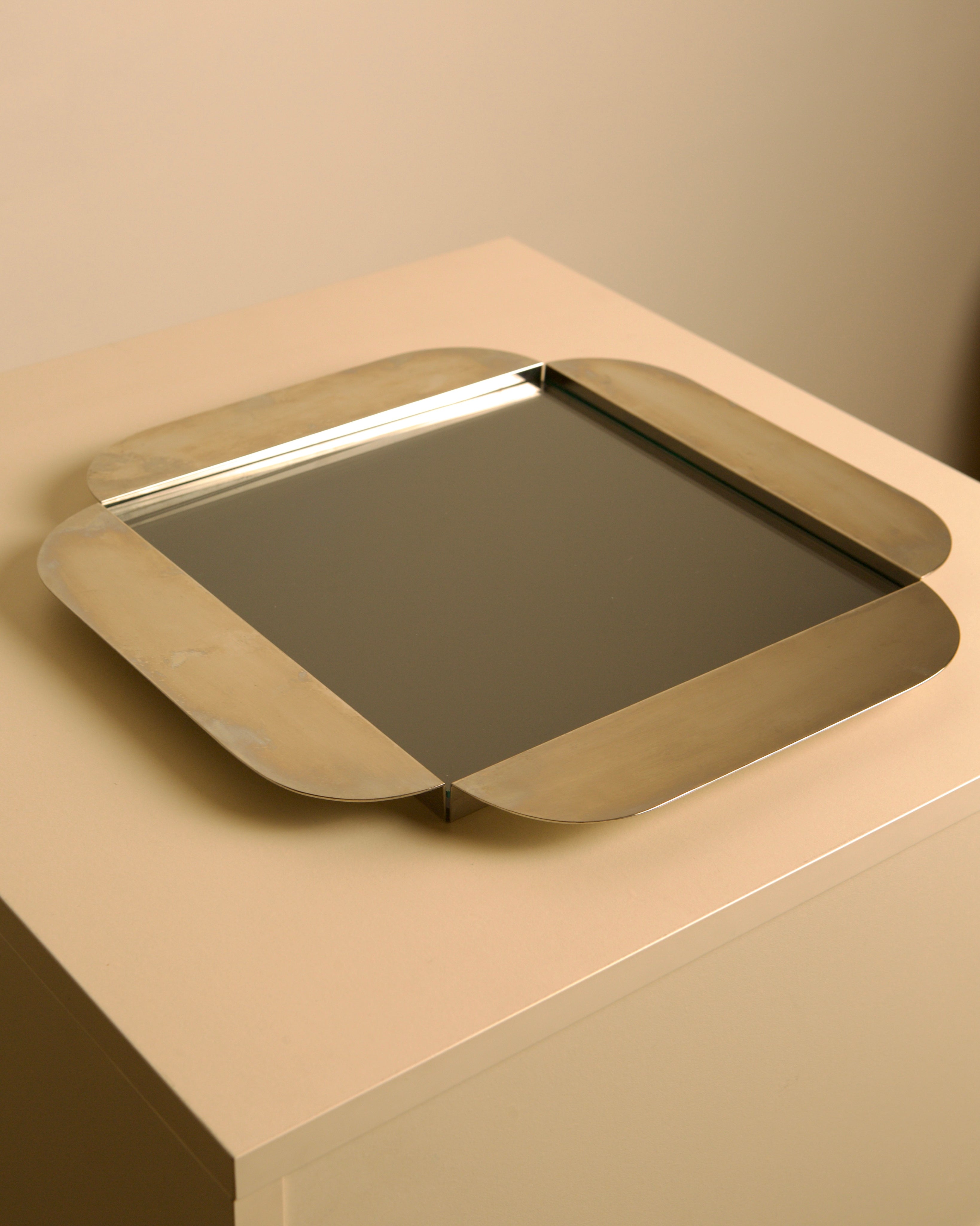 Large Italian Silver-plated Glass and Metal Tray by C&P Italia 70s — close-up of polished silver edge on neutral background