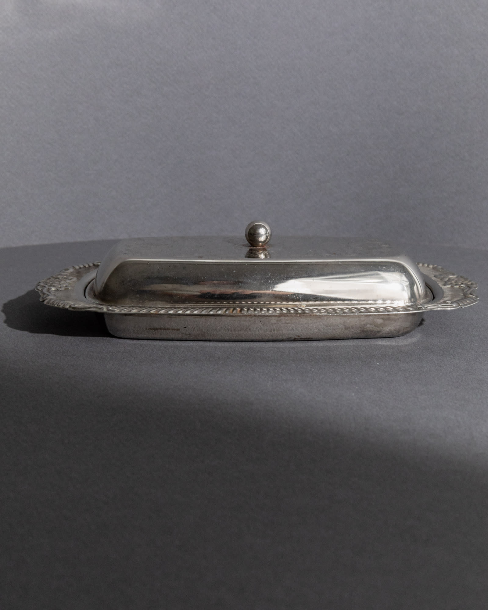 Previous slide Next slide Vintage 1970s Silver Plated Butter Dish, Engraved Ornamental — back view showing smooth silver surf
