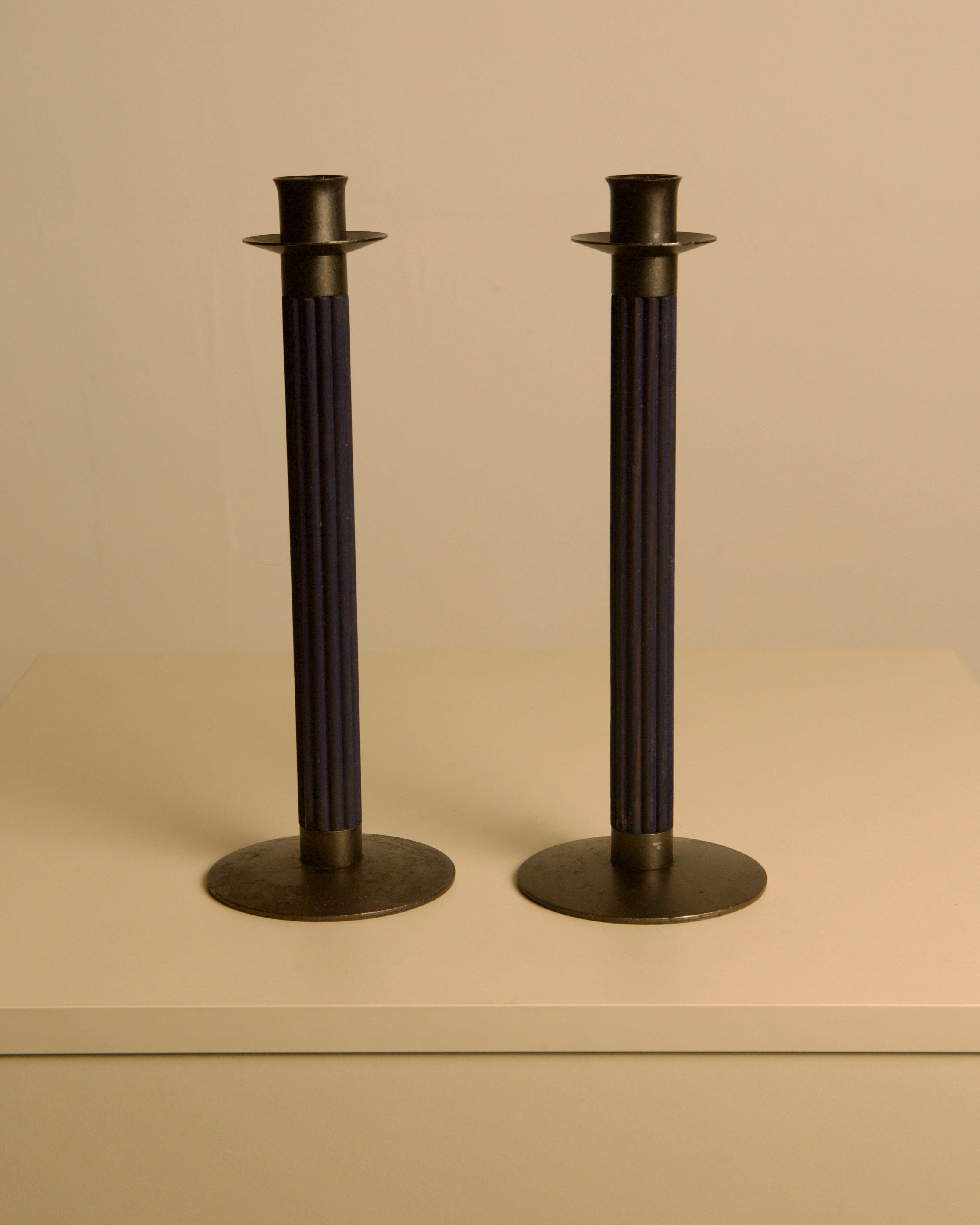 Pair of Swedish Midnight Blue Metal and Wood Candleholders c. 1960 — close-up of candleholders on neutral background