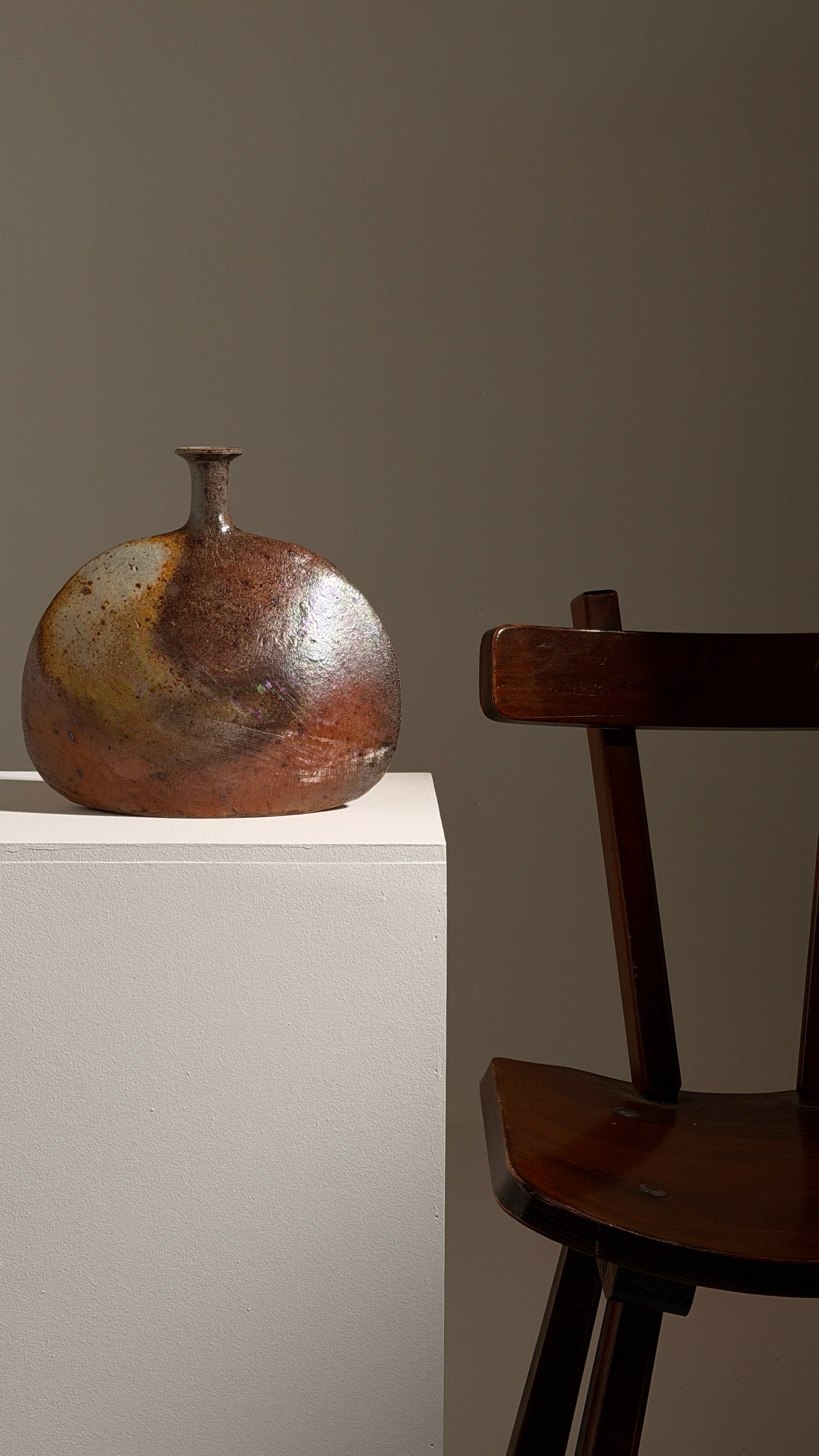 Large bottle vase by Gustave Tiffoche — ceramic vase on pedestal next to wooden chair
