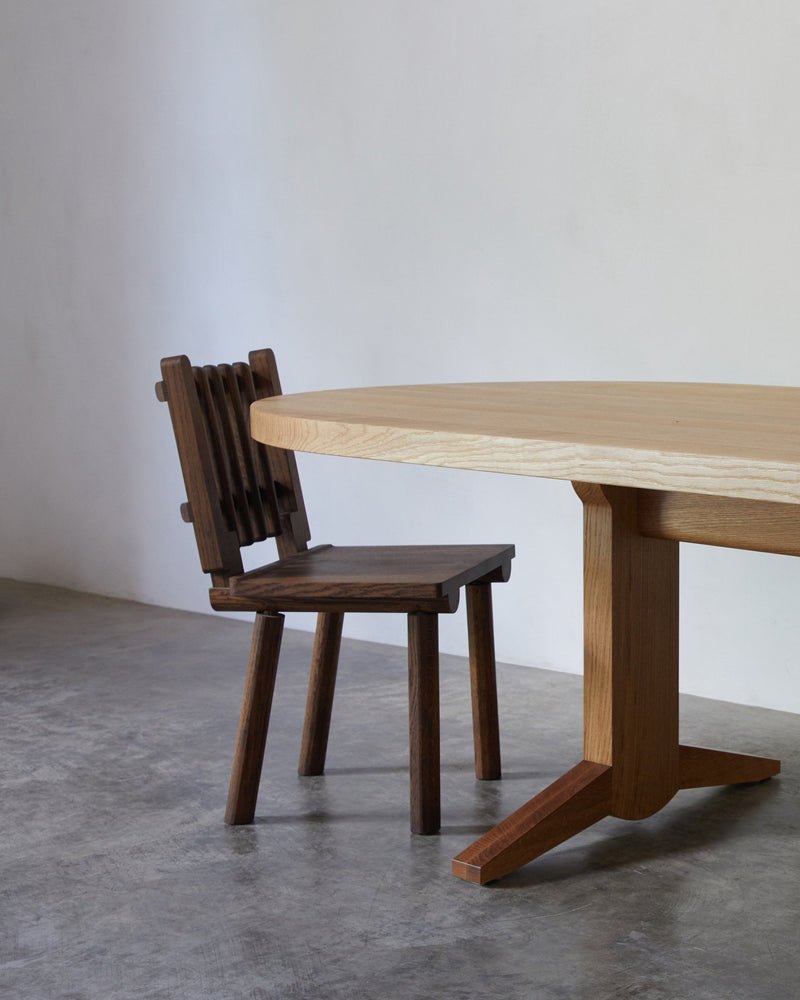 Taverne Chair — angled view beside wooden dining table